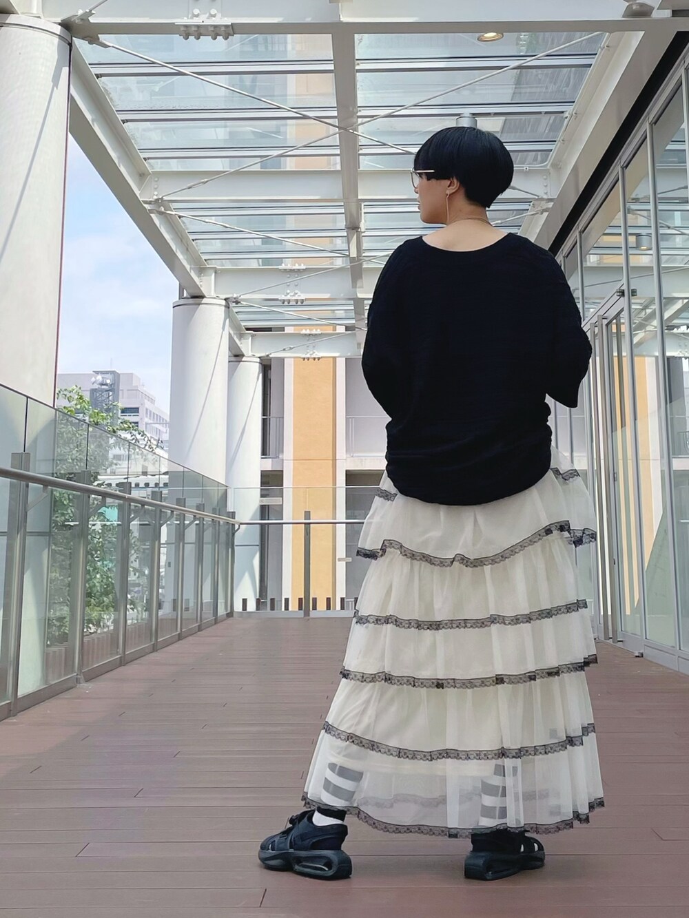 ホワイト系のスカート、ホワイト系のスカート、ブラック系のチュニックを着用したレディースの秋コーディネートの5枚目の写真