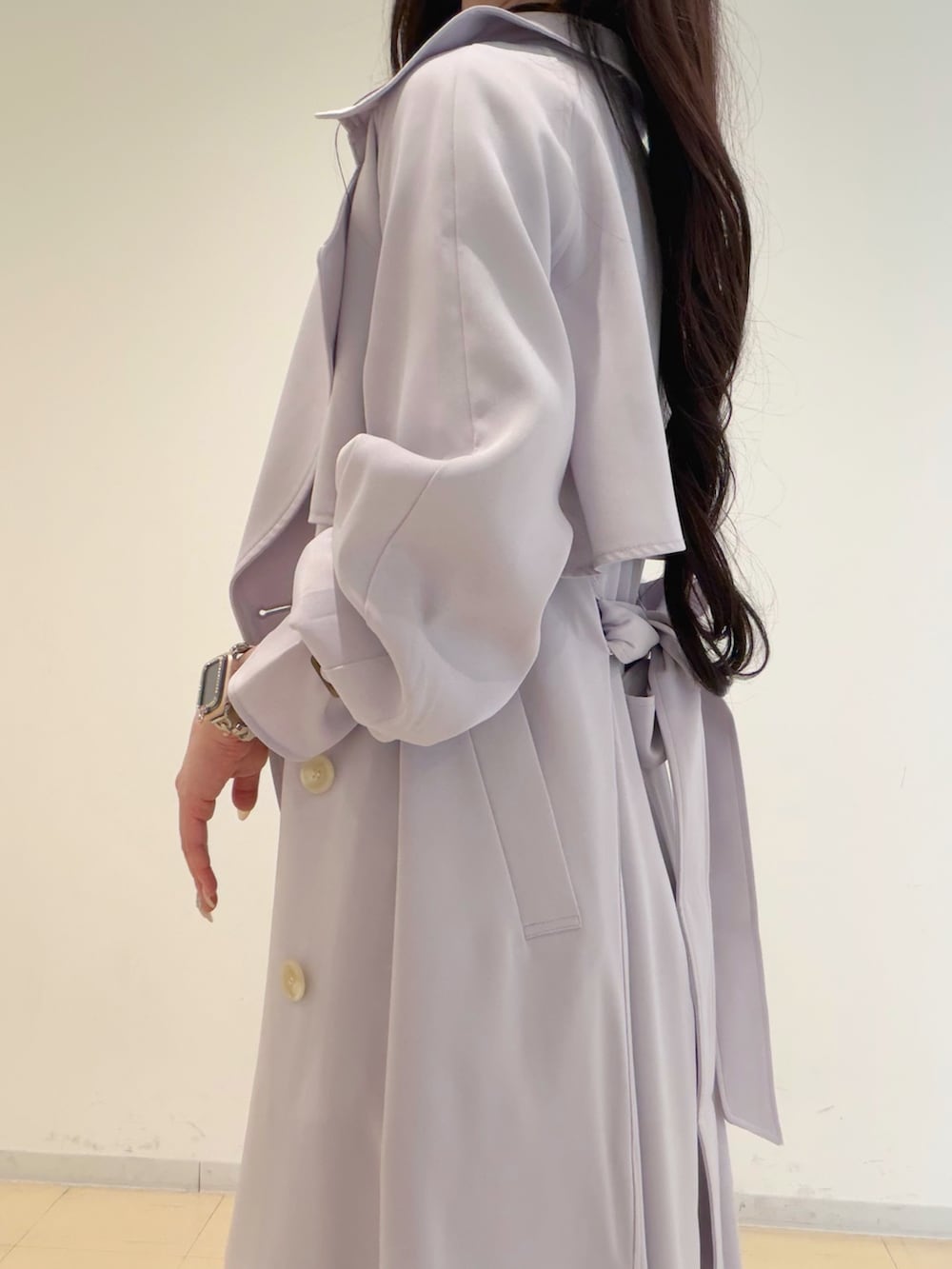 ブラック系のワンピース、パープル系のトレンチコート、ホワイト系のハンドバッグを着用したレディースの春コーディネートの7枚目の写真