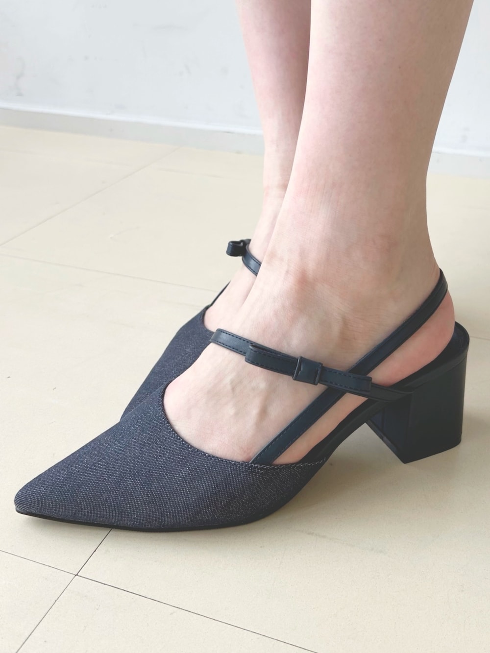 ホワイト系のハンドバッグ、ブルー系のパンプス、ホワイト系のカーディガン/ボレロを着用したレディースの夏コーディネートの7枚目の写真