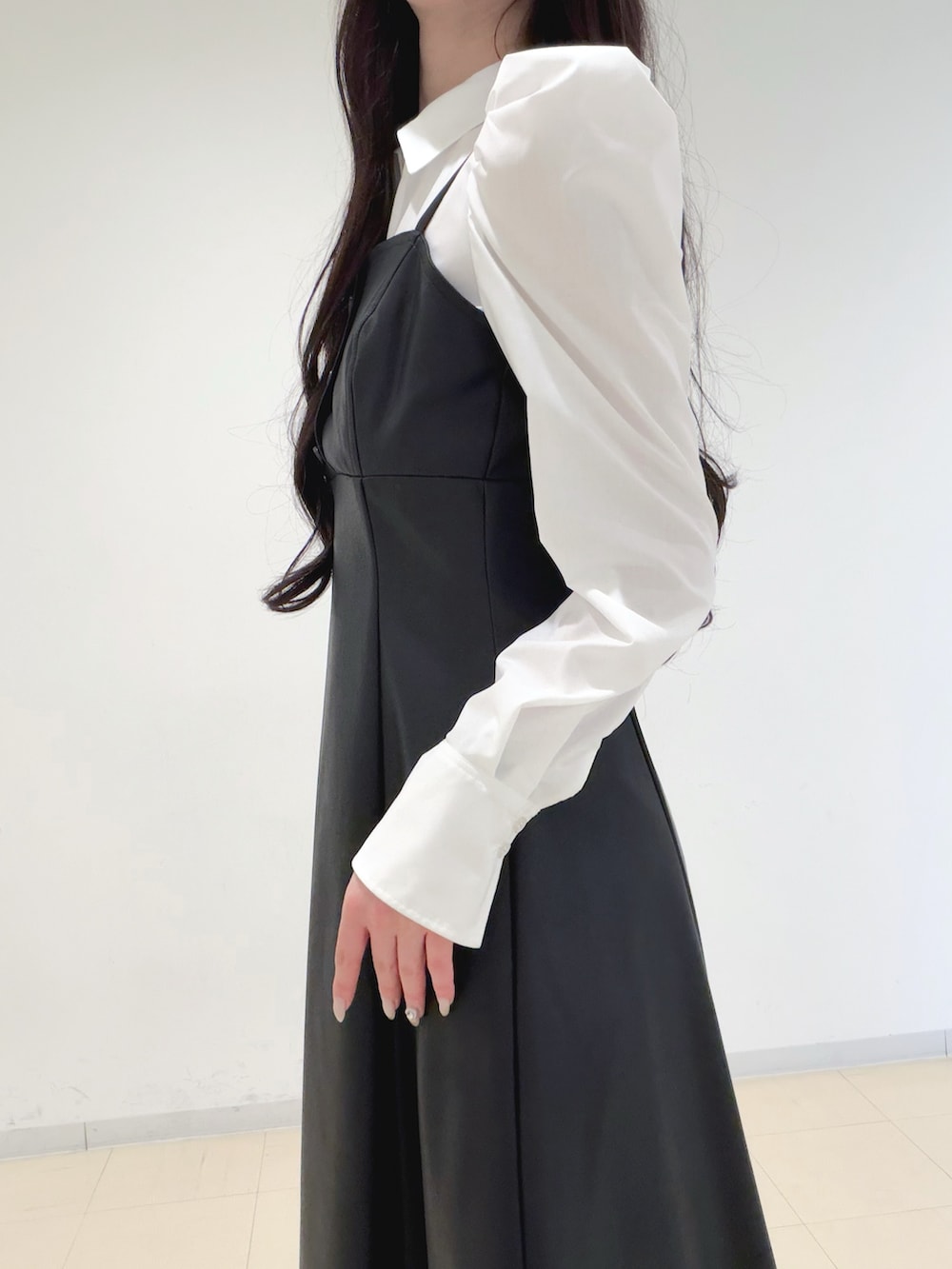 ブラック系のワンピース、ベージュ系のトレンチコート、ブラウン系のハンドバッグを着用したレディースの冬コーディネートの8枚目の写真