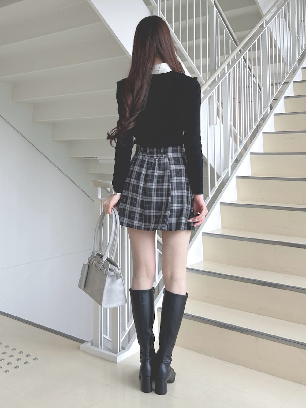 その他のスカート、ブラック系のブーツ、グレー系のハンドバッグを着用したレディースの秋コーディネートの4枚目の写真