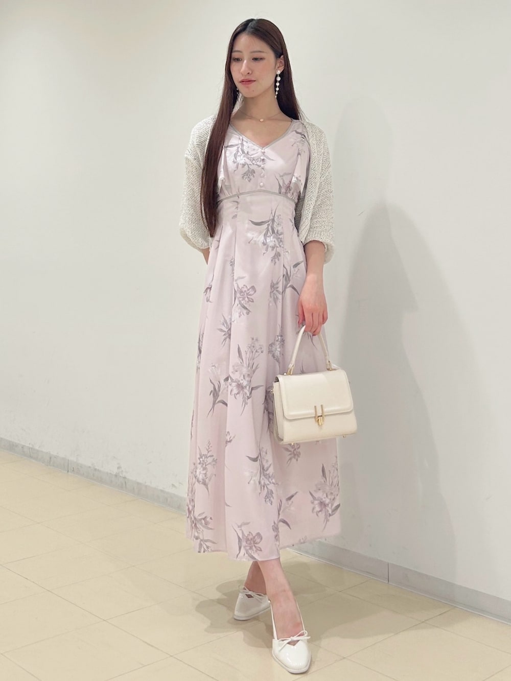 ピンク系のワンピース、ホワイト系のパンプス、ホワイト系のハンドバッグを着用したレディースの夏コーディネートの3枚目の写真
