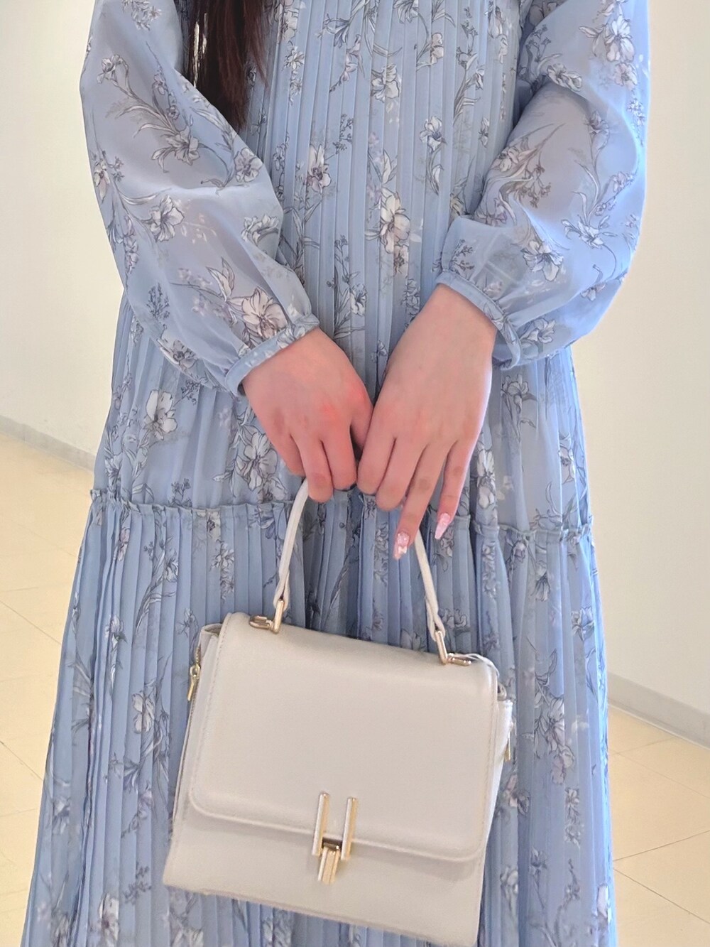 ブルー系のワンピース、ホワイト系のパンプス、ホワイト系のハンドバッグを着用したレディースの春コーディネートの7枚目の写真