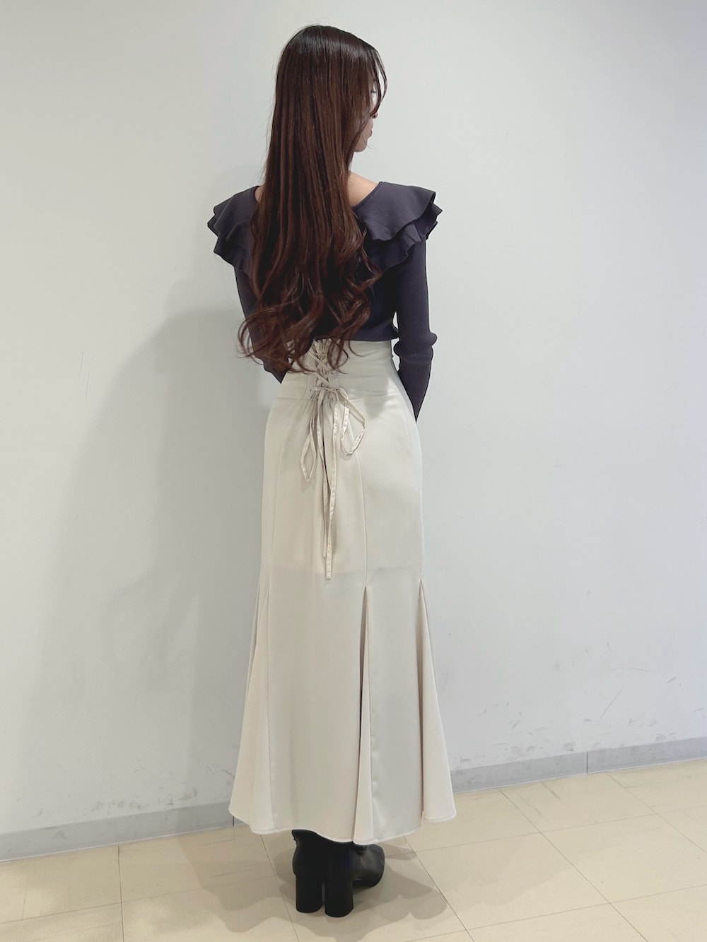 ホワイト系のスカート、ブラック系のブーツ、グレー系のニット/セーターを着用したレディースの冬コーディネートの4枚目の写真