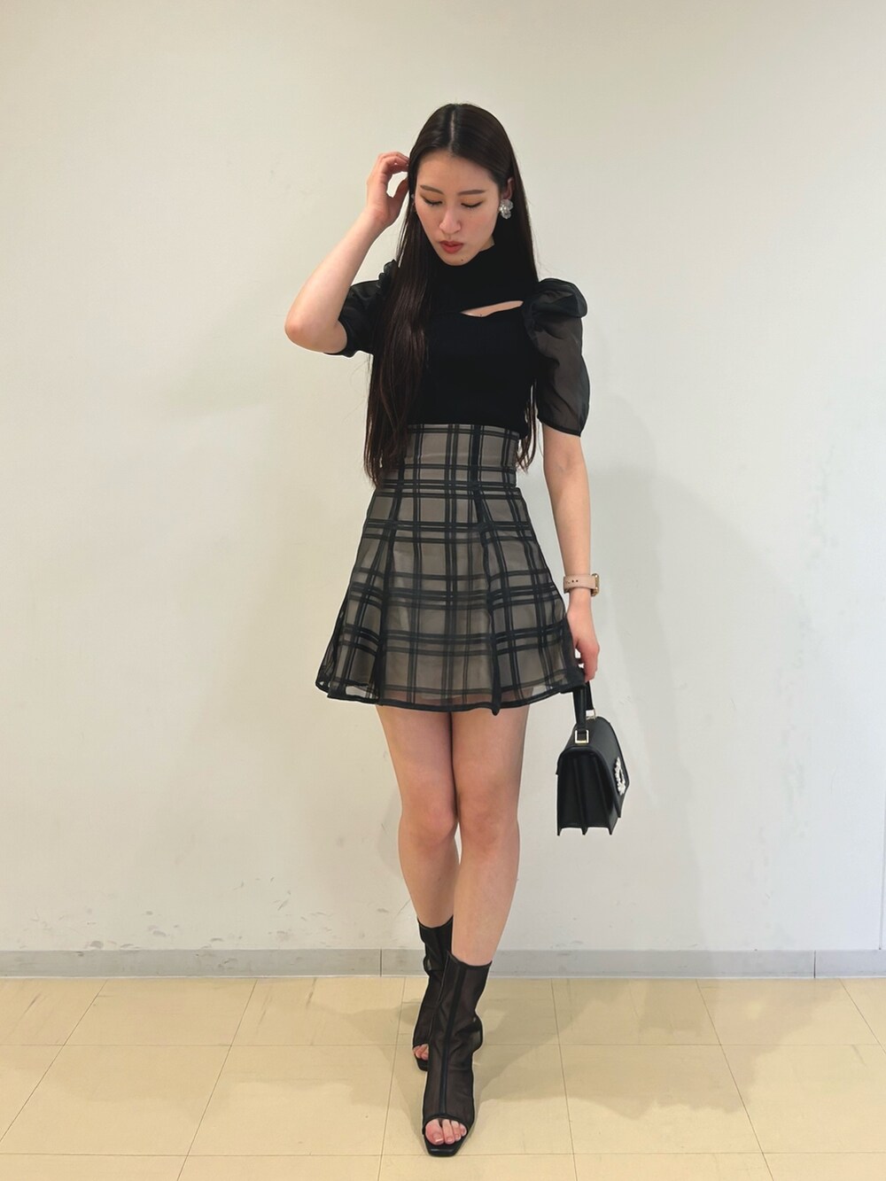 ブラック系のニット/セーター、ブラック系のその他パンツ、ホワイト系のショルダーバッグを着用したレディースの春コーディネートの2枚目の写真