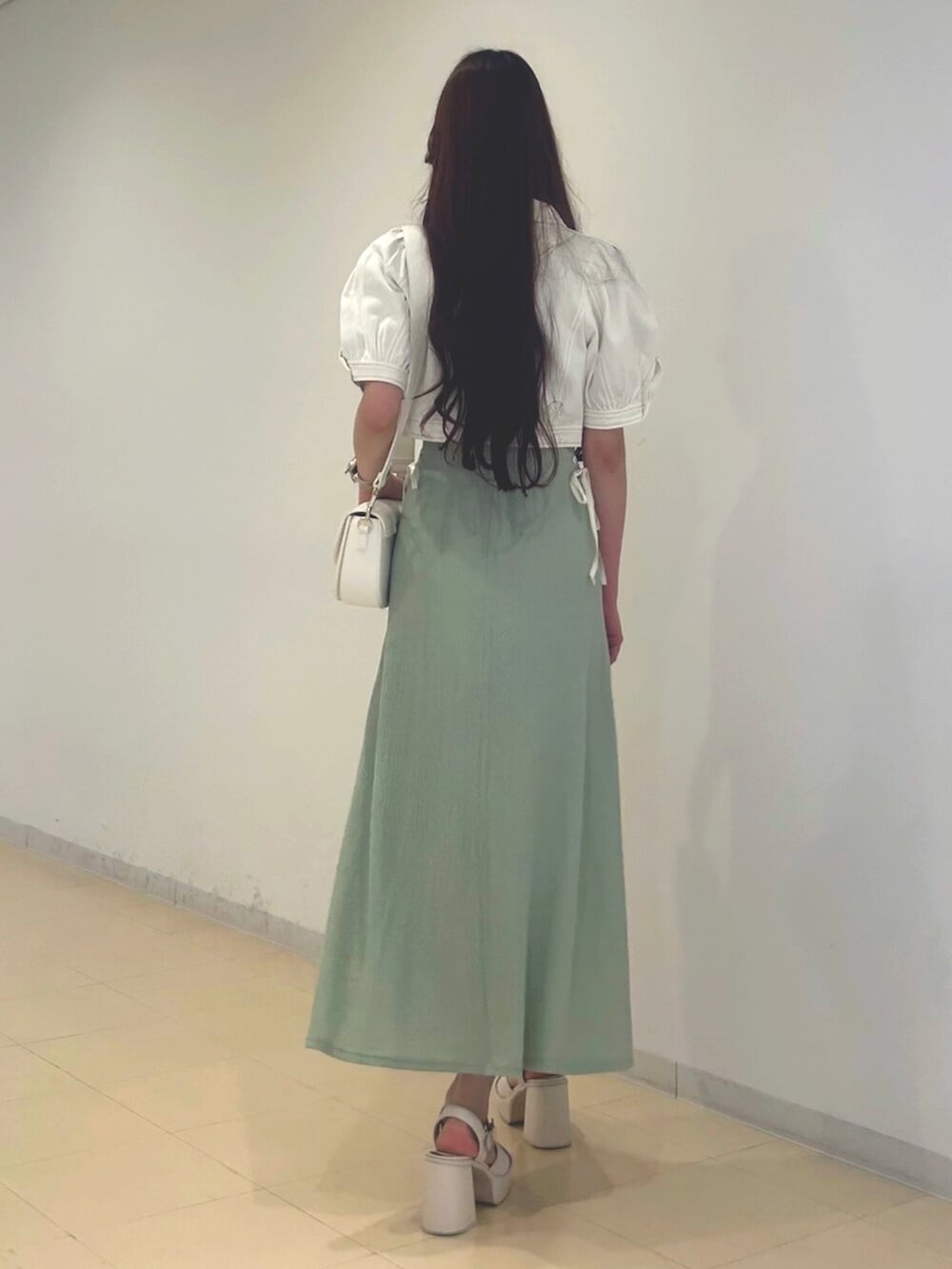 ホワイト系のサンダル、ホワイト系のショルダーバッグ、ホワイト系のデニムジャケットを着用したレディースの夏コーディネートの3枚目の写真