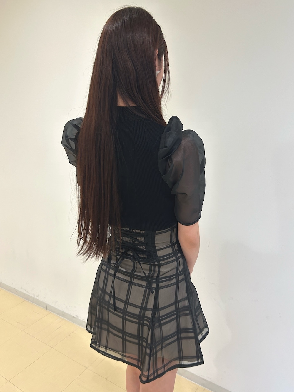 ブラック系のニット/セーター、ブラック系のその他パンツ、ホワイト系のショルダーバッグを着用したレディースの春コーディネートの6枚目の写真