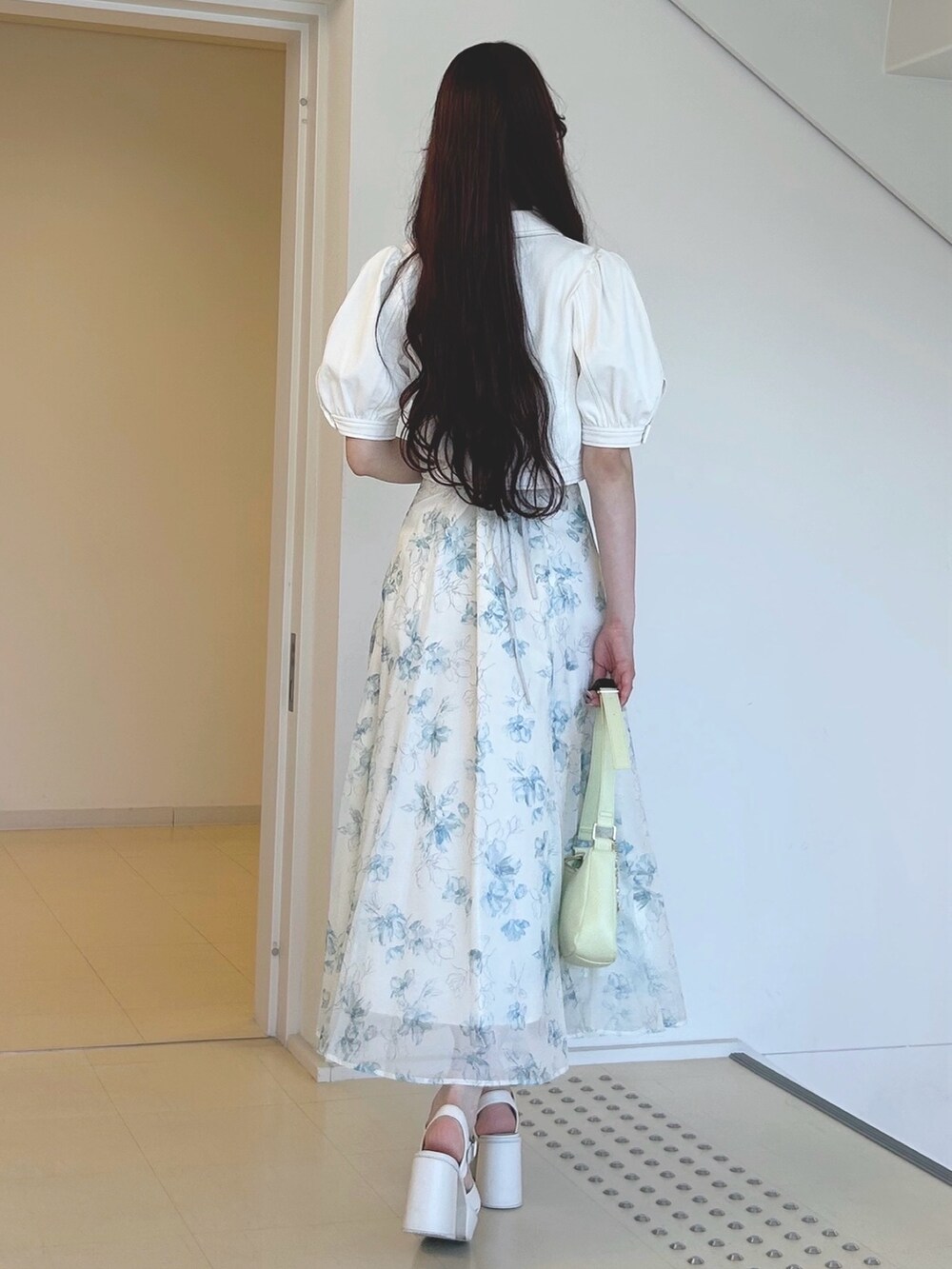 グリーン系のワンピース、グリーン系のハンドバッグ、ホワイト系のサンダルを着用したレディースの夏コーディネートの4枚目の写真