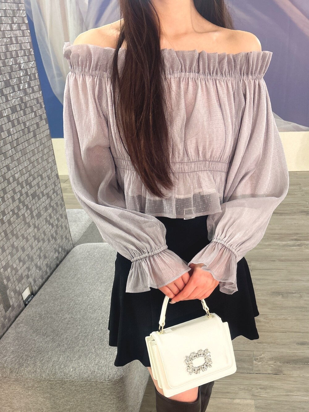 パープル系のシャツ/ブラウス、ホワイト系のショルダーバッグ、ブラウン系のブーツを着用したレディースの冬コーディネートの5枚目の写真