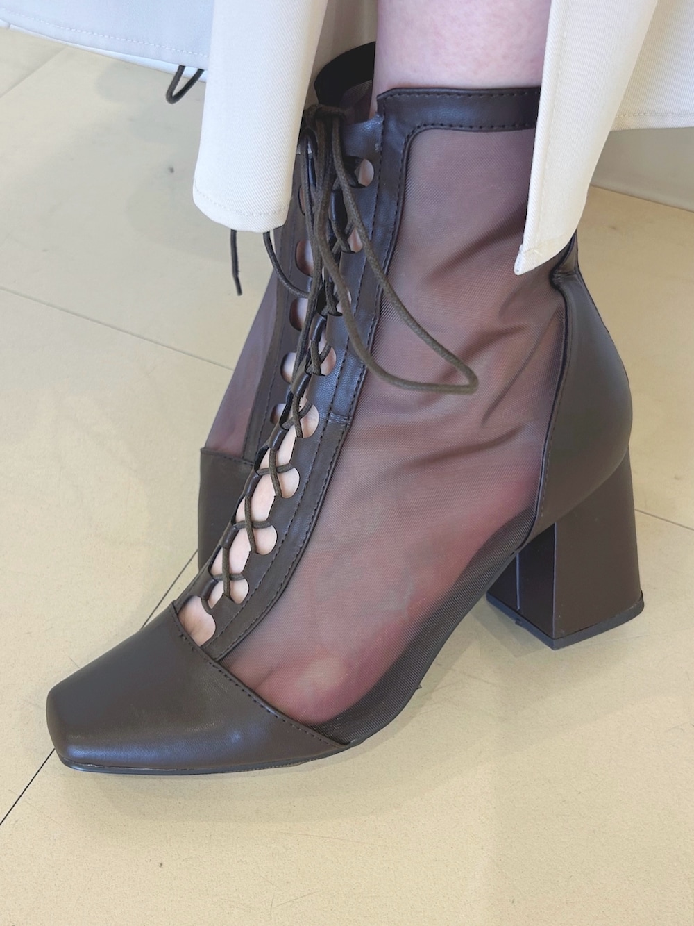 ホワイト系のスカート、ベージュ系のノーカラージャケット、ブラウン系のハンドバッグを着用したレディースの春コーディネートの7枚目の写真