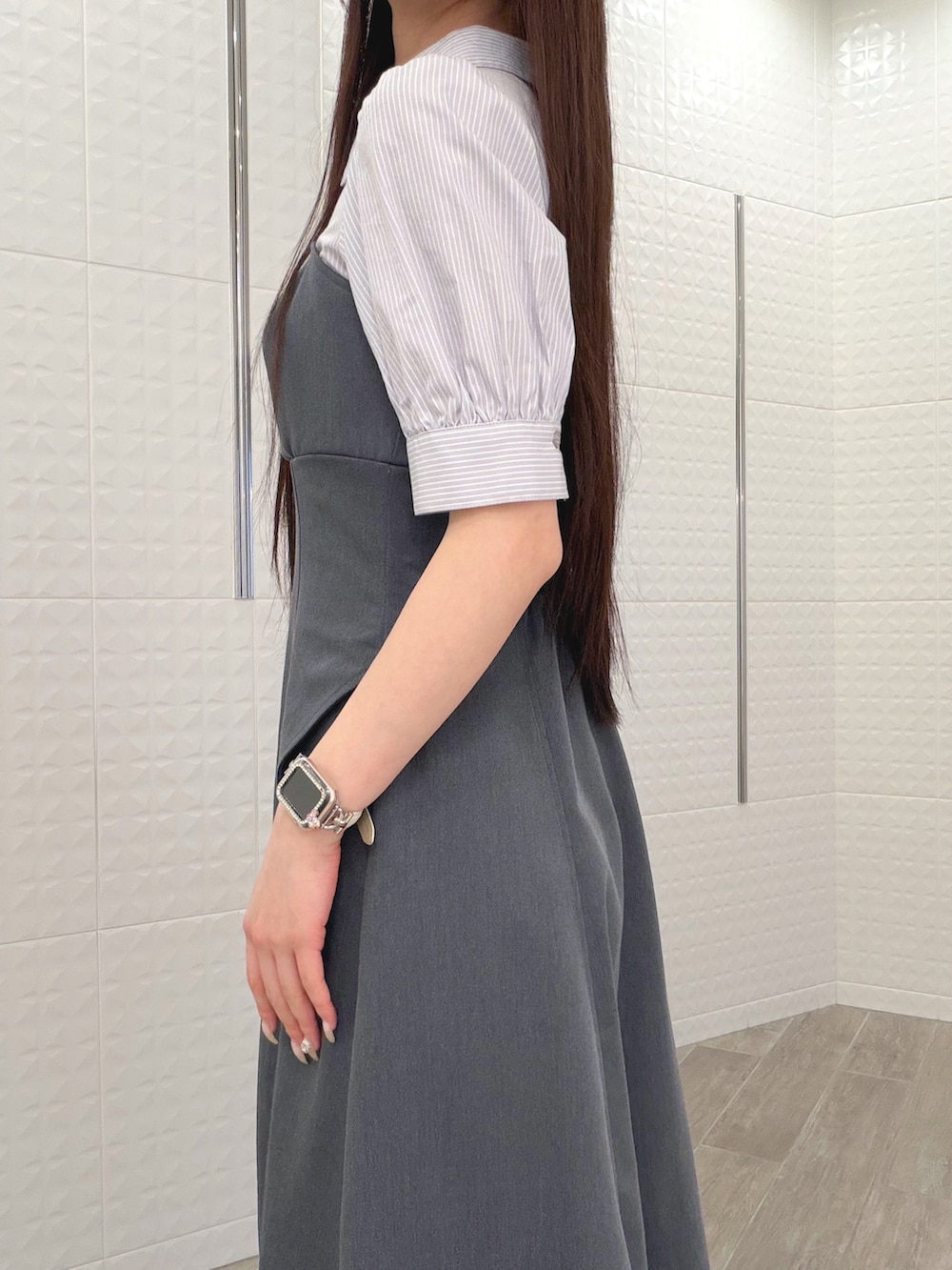 グレー系のワンピース、ホワイト系のハンドバッグ、ブラウン系のパンプスを着用したレディースの春コーディネートの5枚目の写真