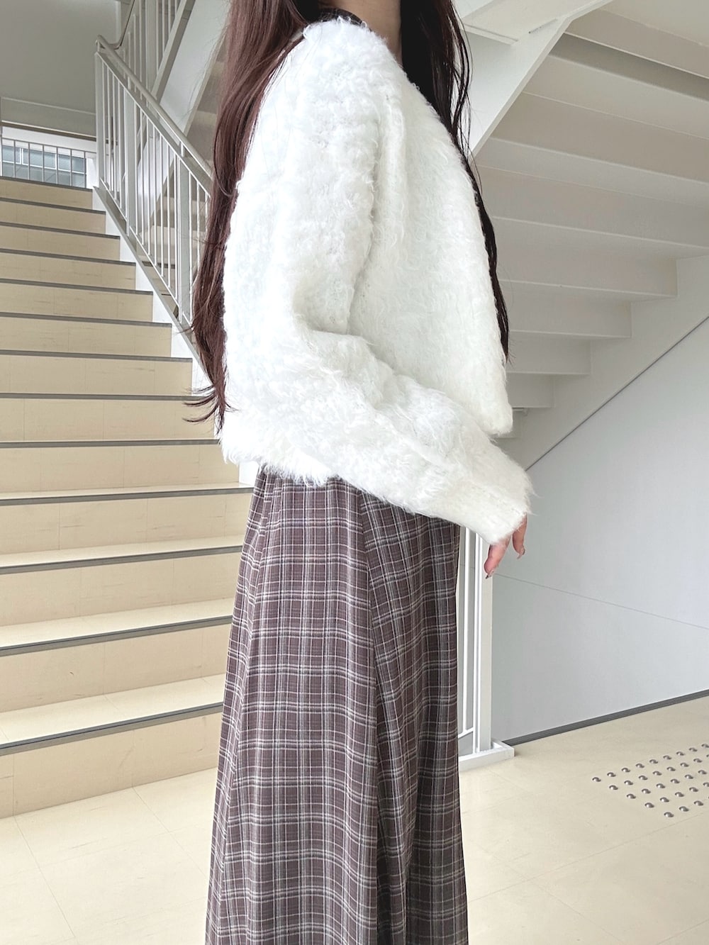 ブラウン系のワンピース、ホワイト系のハンドバッグ、ブラック系のブーツを着用したレディースの秋コーディネートの6枚目の写真