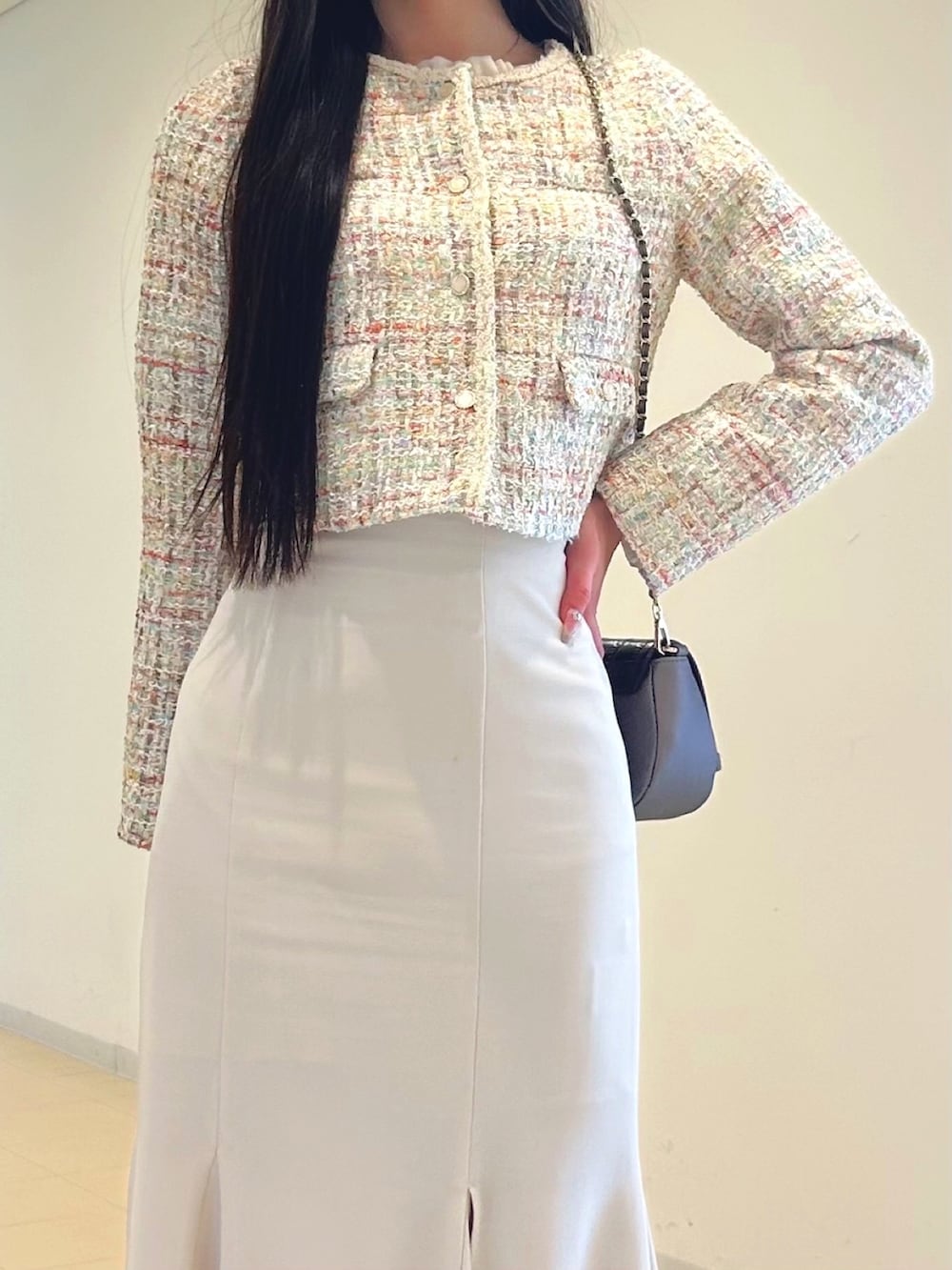 ホワイト系のスカート、ベージュ系のノーカラージャケット、ブラウン系のハンドバッグを着用したレディースの春コーディネートの5枚目の写真