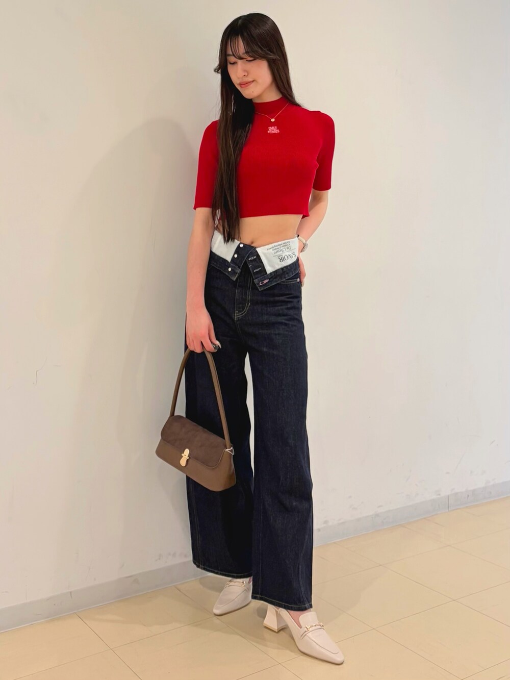 ブルー系のその他パンツ、レッド系のニット/セーター、ブラウン系のハンドバッグを着用したレディースの春コーディネートの3枚目の写真