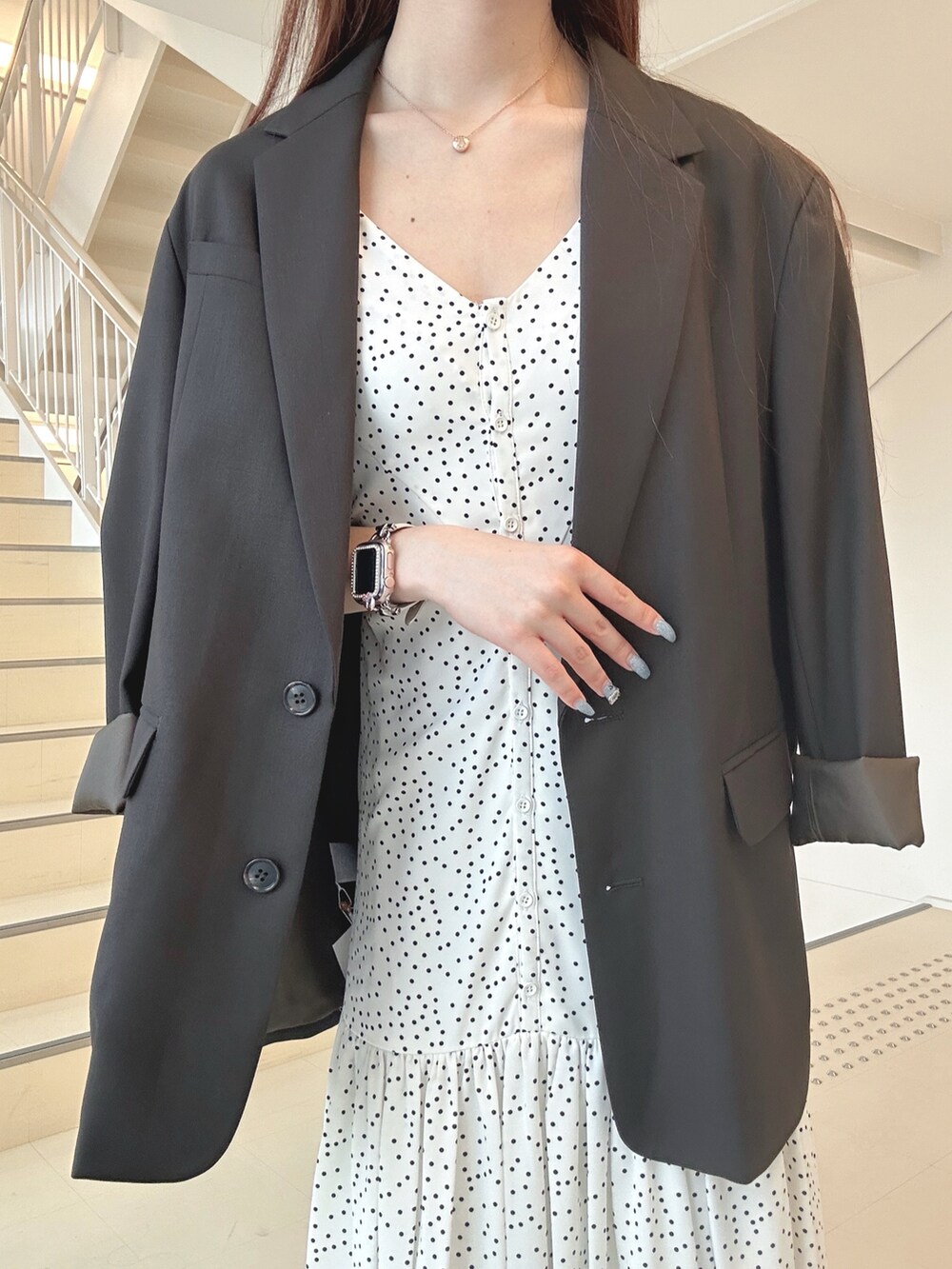 ブラック系のハンドバッグ、ホワイト系のパンプス、ブラウン系のテーラードジャケットを着用したレディースの秋コーディネートの6枚目の写真