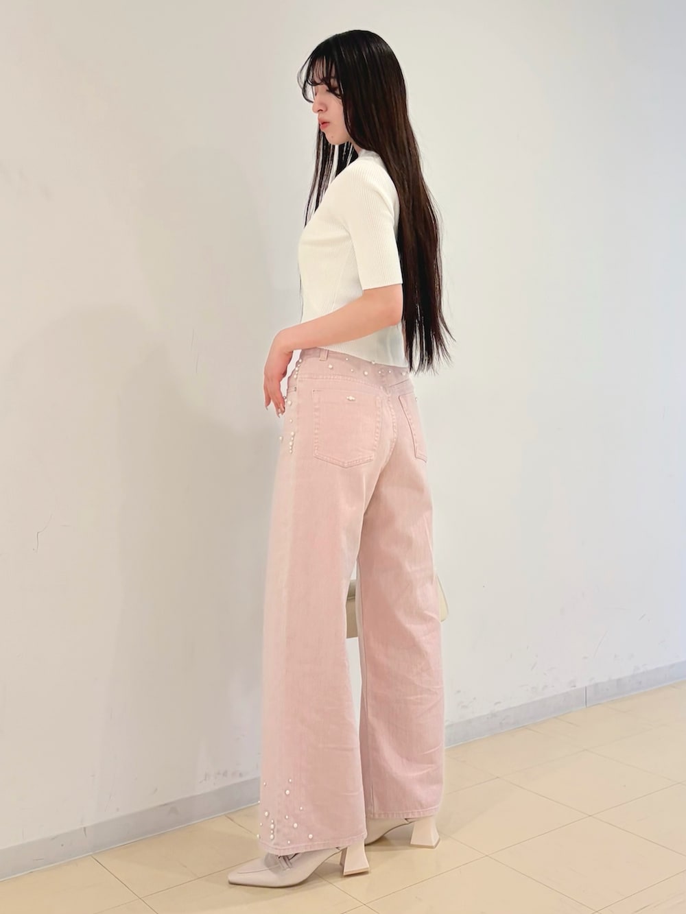 ホワイト系のニット/セーター、ホワイト系のキャミソール、ピンク系のデニムパンツを着用したレディースの春コーディネートの3枚目の写真