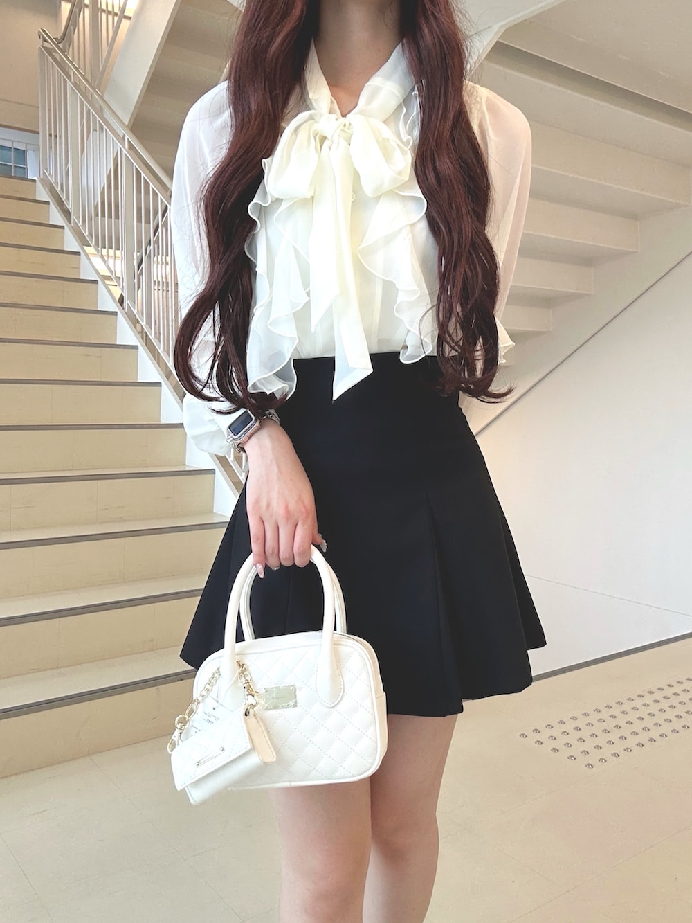 ホワイト系のシャツ/ブラウス、ブラック系のスカート、ブラウン系のブーツを着用したレディースの秋コーディネートの4枚目の写真