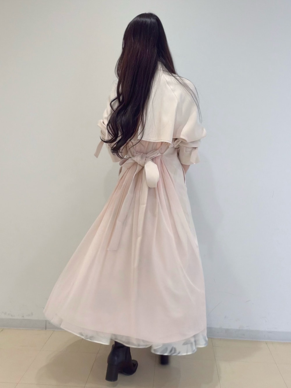 ホワイト系のスカート、ブラウン系のブーツ、ホワイト系のショルダーバッグを着用したレディースの冬コーディネートの4枚目の写真