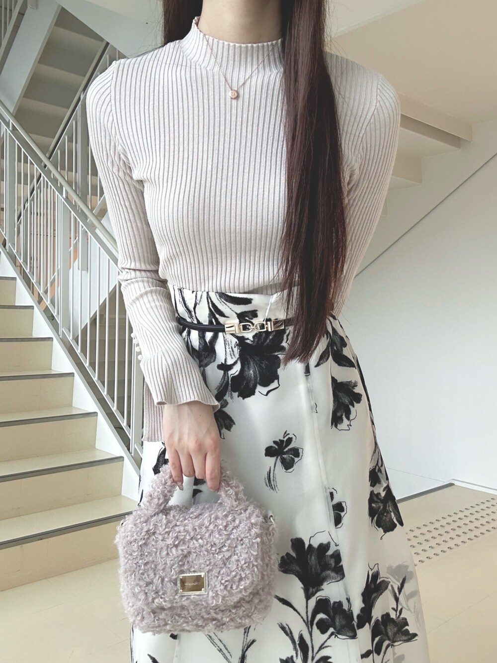 ホワイト系のスカート、ベージュ系のニット/セーター、ピンク系のハンドバッグを着用したレディースの秋コーディネートの5枚目の写真