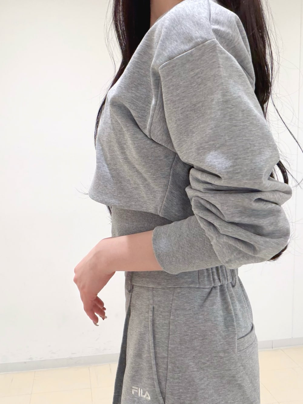 グレー系のその他パンツ、グレー系のTシャツ/カットソー、ホワイト系のパンプスを着用したレディースの冬コーディネートの6枚目の写真