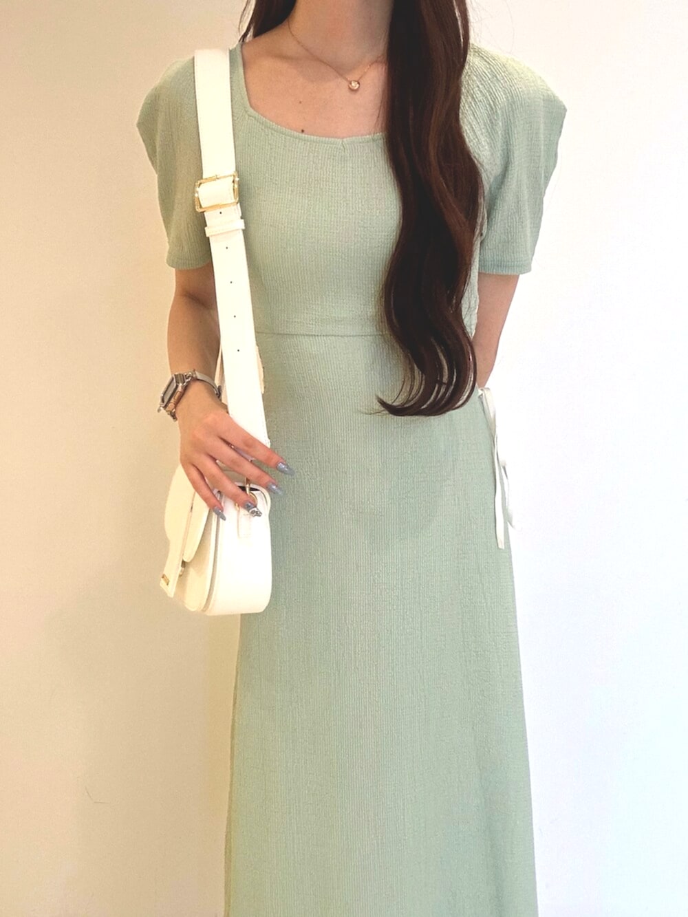 ホワイト系のサンダル、ホワイト系のショルダーバッグ、グリーン系のワンピースを着用したレディースの夏コーディネートの5枚目の写真