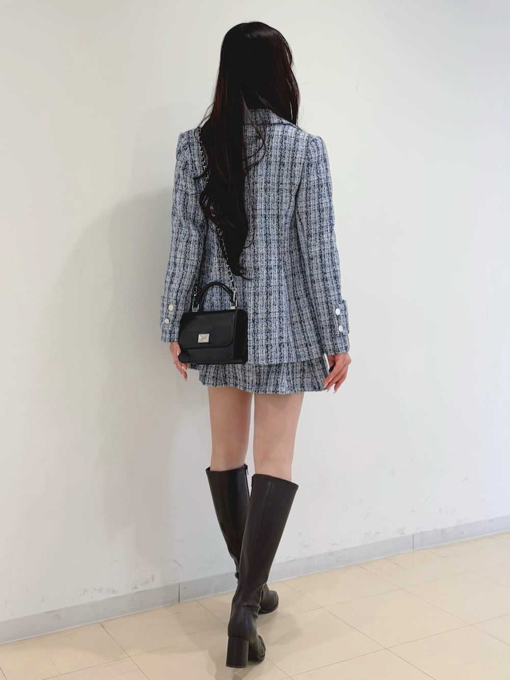 ブルー系のテーラードジャケット、ブルー系のスカート、ホワイト系のニット/セーターを着用したレディースの冬コーディネートの3枚目の写真