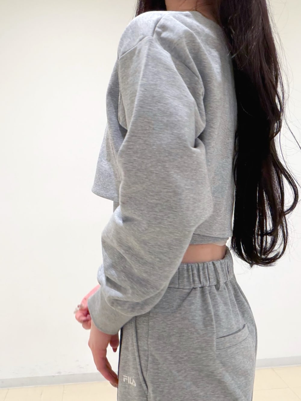 グレー系のその他パンツ、グレー系のTシャツ/カットソー、ホワイト系のパンプスを着用したレディースの冬コーディネートの7枚目の写真