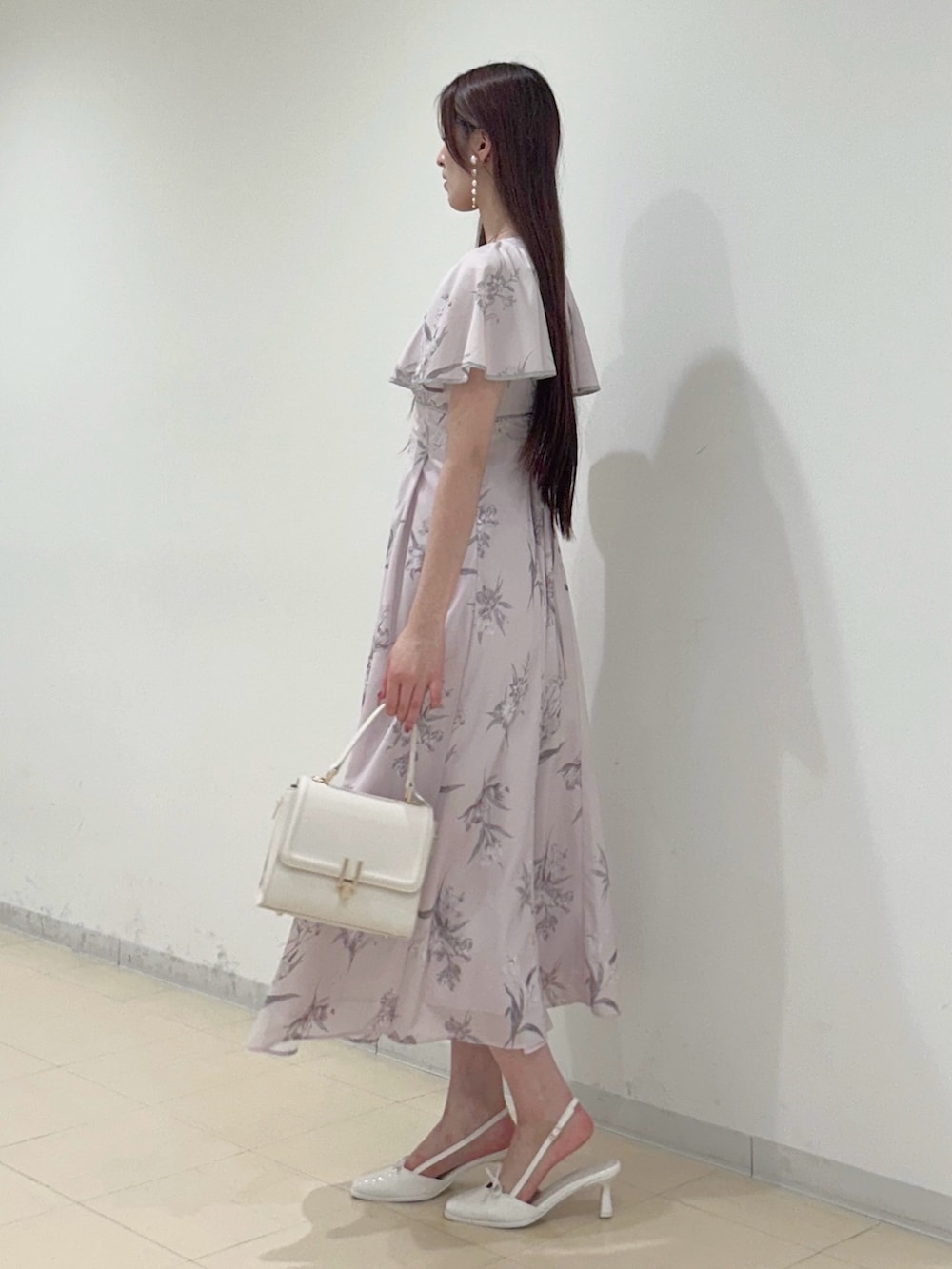 ピンク系のワンピース、ホワイト系のハンドバッグ、ホワイト系のパンプスを着用したレディースの夏コーディネートの2枚目の写真