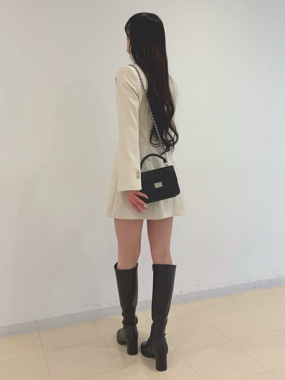 ホワイト系のワンピース、ホワイト系のニット/セーター、ブラック系のハンドバッグを着用したレディースの冬コーディネートの3枚目の写真