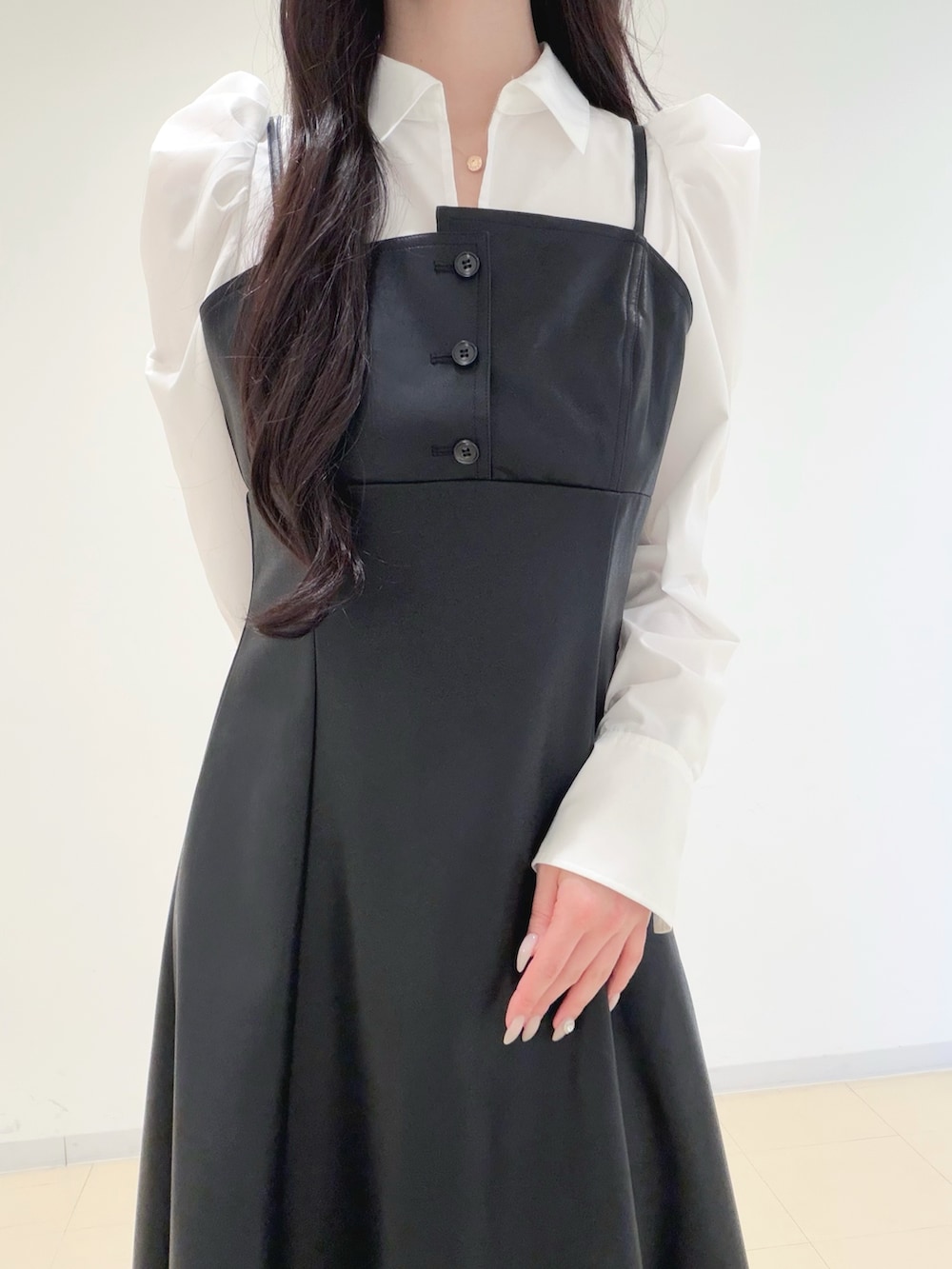 ブラック系のワンピース、ベージュ系のトレンチコート、ブラウン系のハンドバッグを着用したレディースの冬コーディネートの7枚目の写真