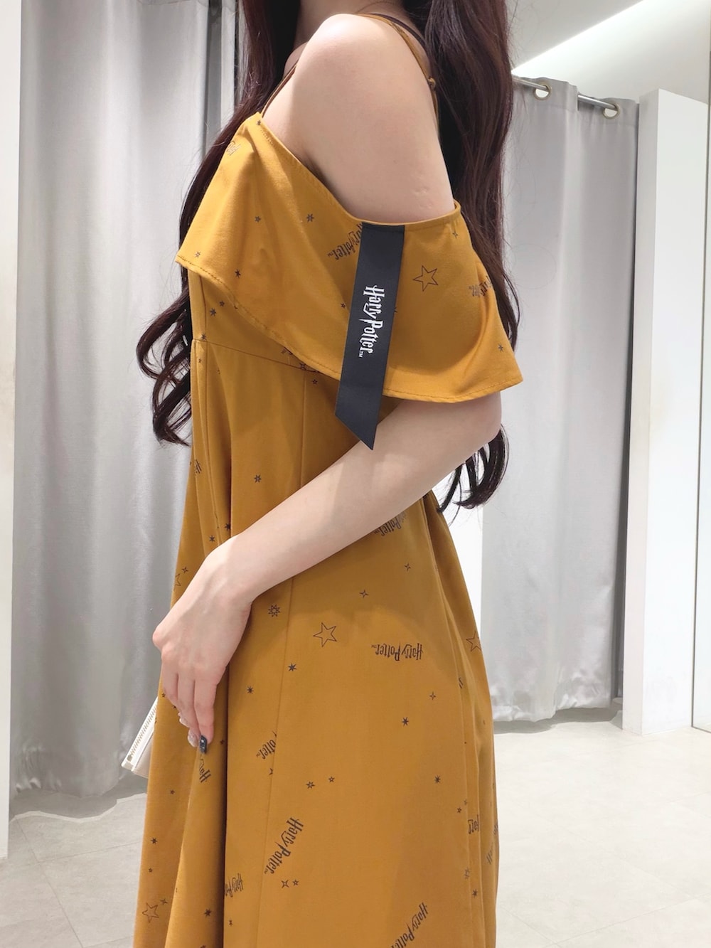 イエロー系のワンピース、ブラウン系のショルダーバッグ、ブラウン系のブーツを着用したレディースの夏コーディネートの6枚目の写真