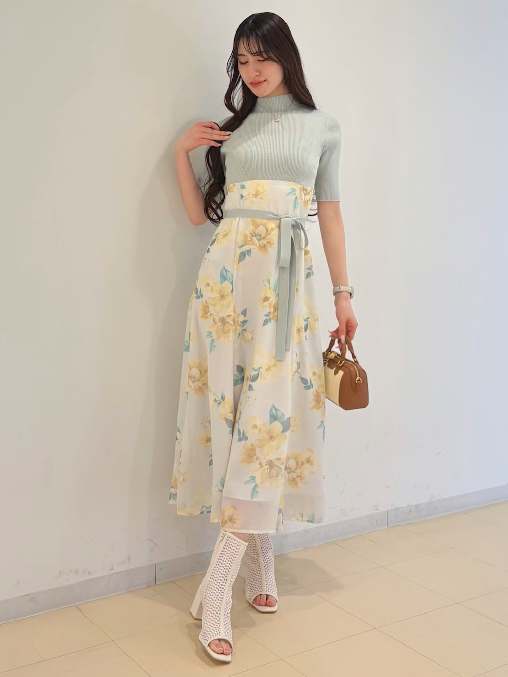 グリーン系のワンピース、ブルー系のデニムジャケット、ブラウン系のハンドバッグを着用したレディースの春コーディネートの2枚目の写真