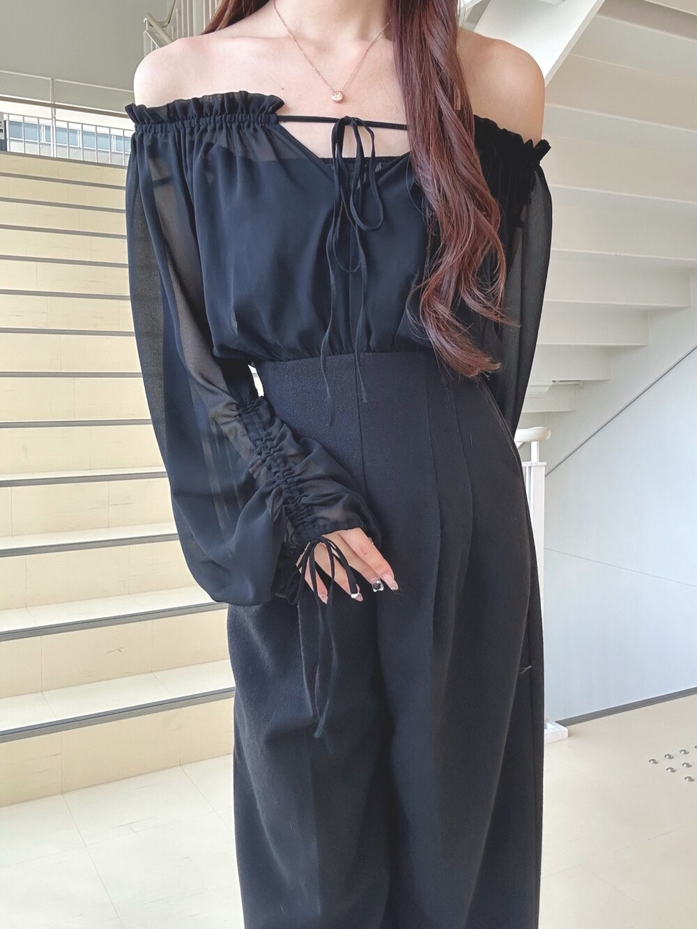 ブラック系のワンピース、ブラック系のショルダーバッグ、ブラック系のパンプスを着用したレディースの秋コーディネートの5枚目の写真