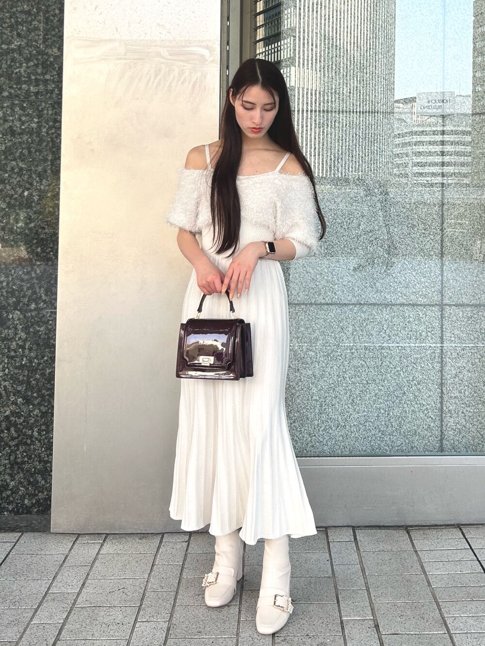 ホワイト系のワンピース、レッド系のハンドバッグ、ホワイト系のブーツを着用したレディースの冬コーディネートの2枚目の写真