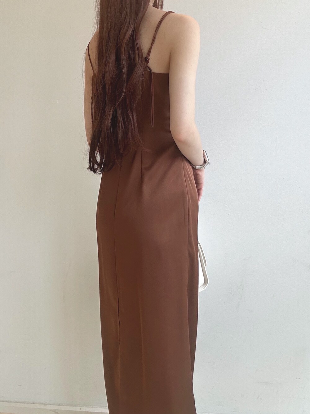 ブラウン系のワンピース、ホワイト系のハンドバッグ、ホワイト系のチューブトップを着用したレディースの夏コーディネートの7枚目の写真