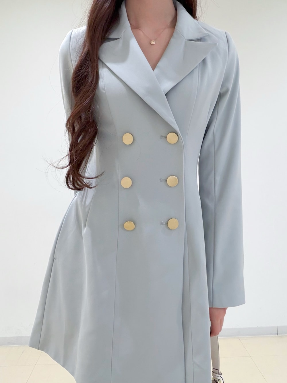 グリーン系のワンピース、ホワイト系のキャミソール、ホワイト系のショルダーバッグを着用したレディースの冬コーディネートの4枚目の写真