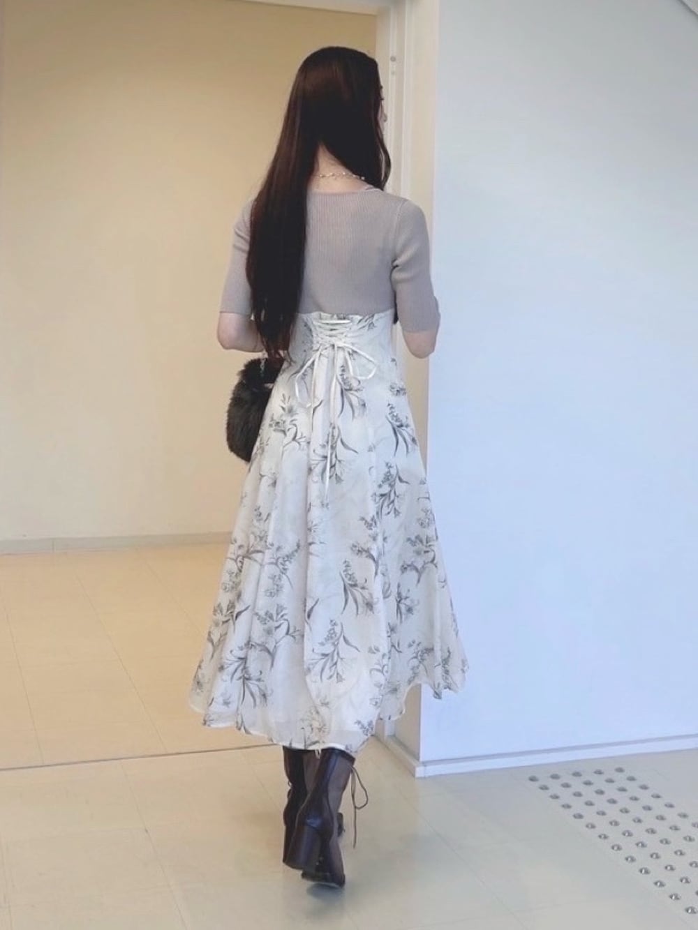 ベージュ系のワンピース、ホワイト系のカーディガン/ボレロ、ブラウン系のハンドバッグを着用したレディースの秋コーディネートの4枚目の写真