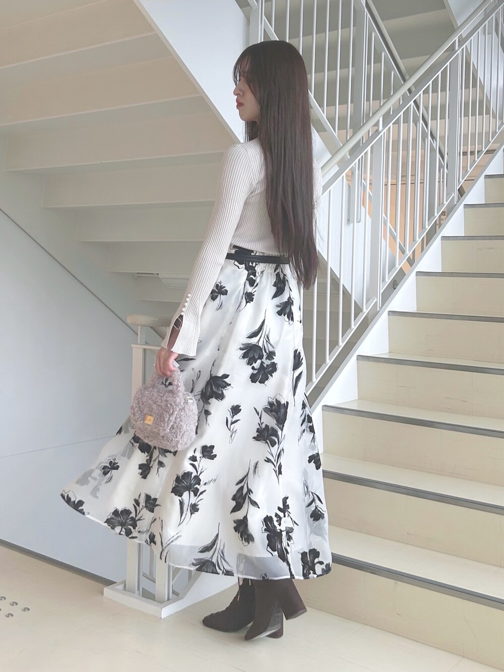 ホワイト系のスカート、ベージュ系のニット/セーター、ピンク系のハンドバッグを着用したレディースの秋コーディネートの2枚目の写真