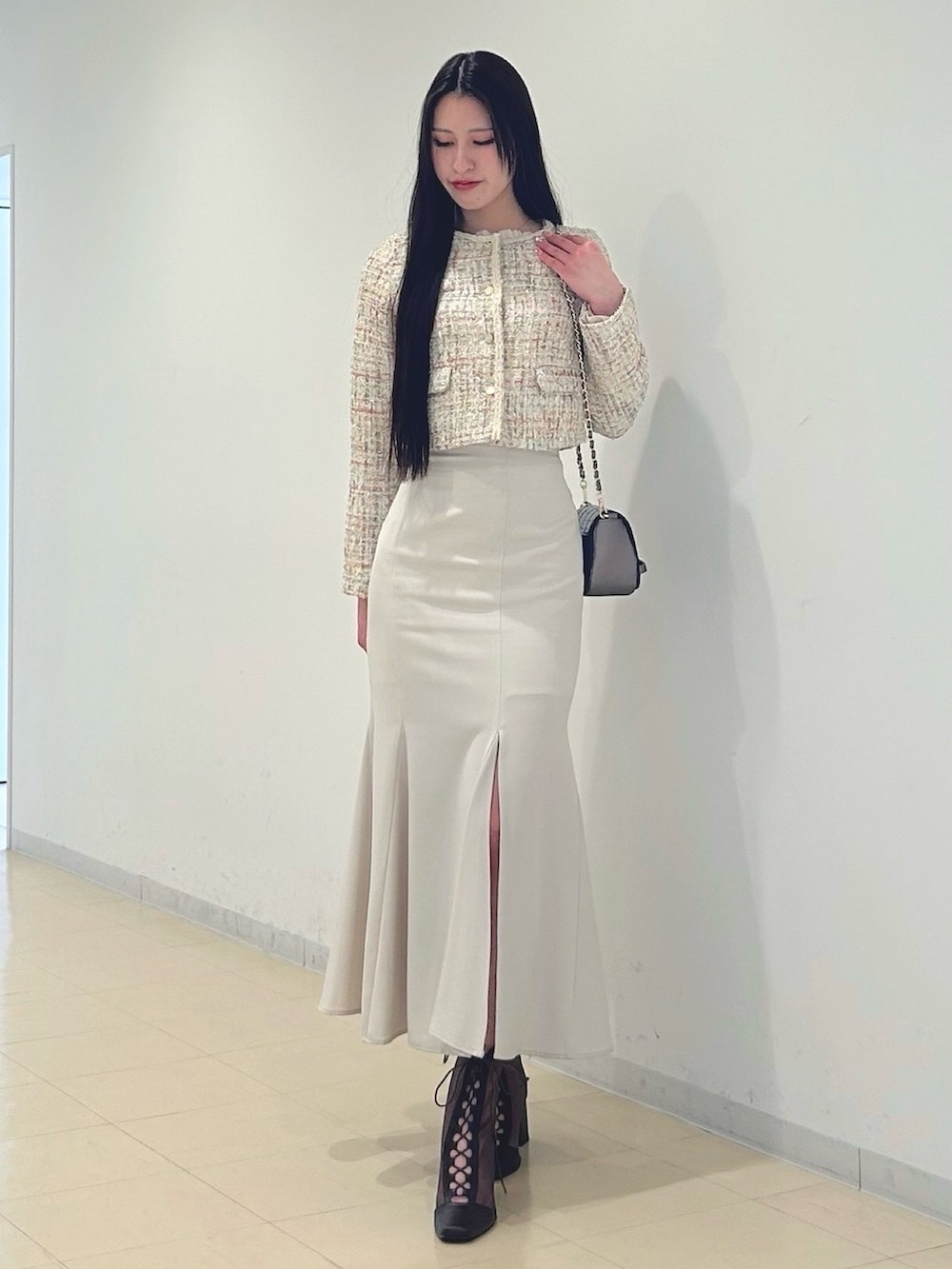 ホワイト系のスカート、ベージュ系のノーカラージャケット、ブラウン系のハンドバッグを着用したレディースの春コーディネートの3枚目の写真