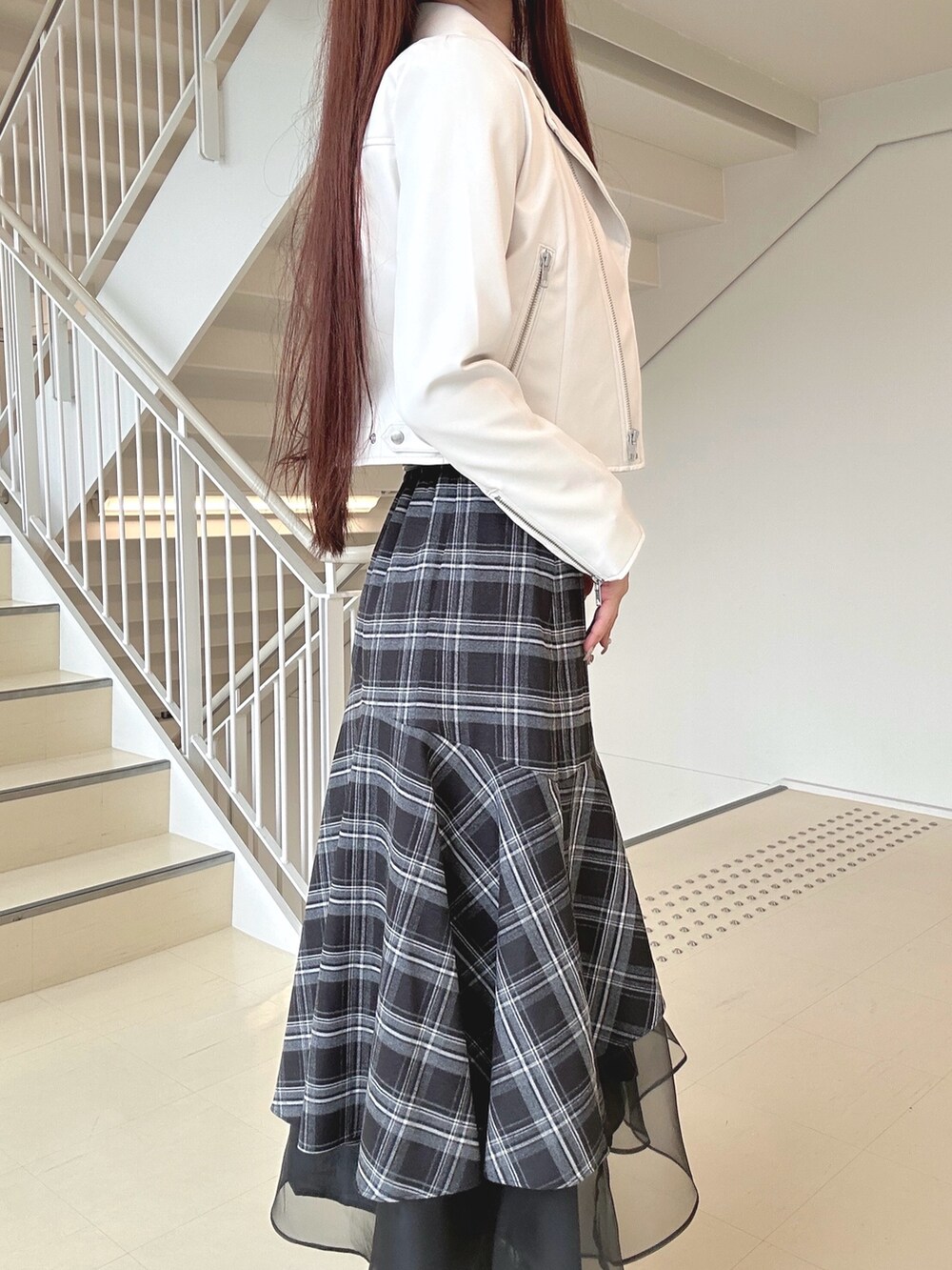 ブラック系のブーツ、ブラック系のスカート、ピンク系のハンドバッグを着用したレディースの秋コーディネートの6枚目の写真