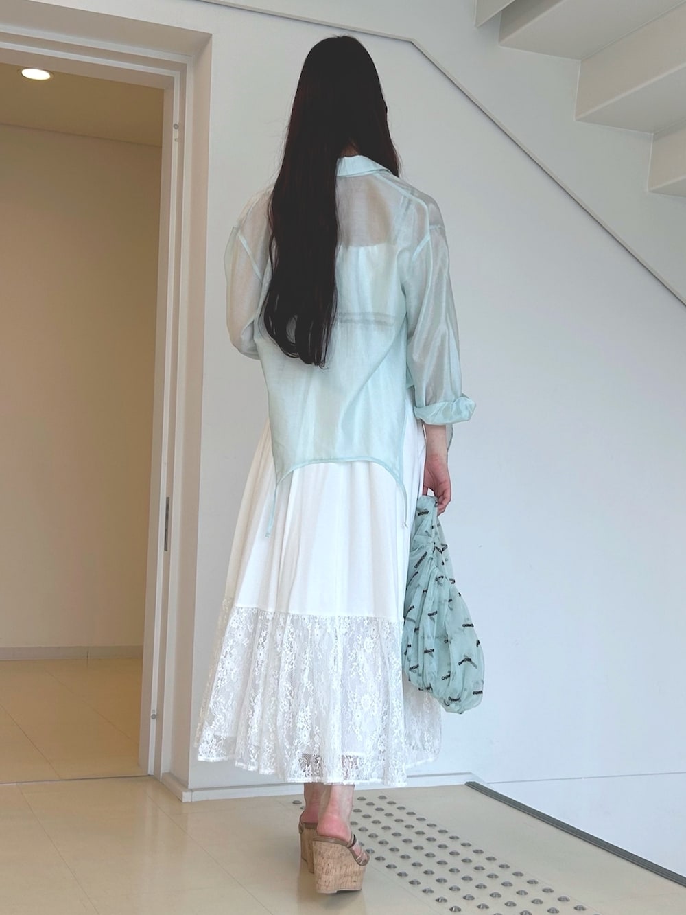 グリーン系のハンドバッグ、ホワイト系のワンピース、ブラウン系のサンダルを着用したレディースの夏コーディネートの4枚目の写真