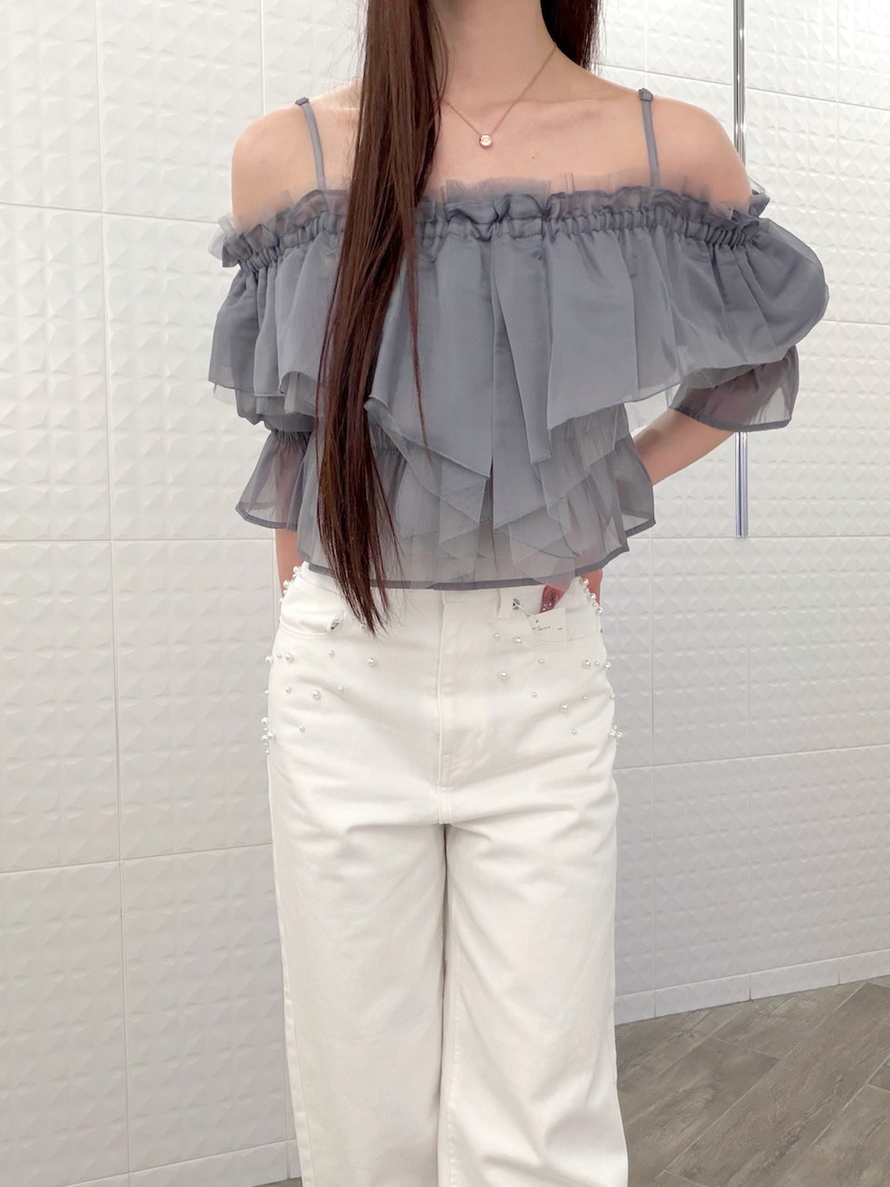 ホワイト系のデニムパンツ、グレー系のシャツ/ブラウス、ブラウン系のハンドバッグを着用したレディースの春コーディネートの5枚目の写真