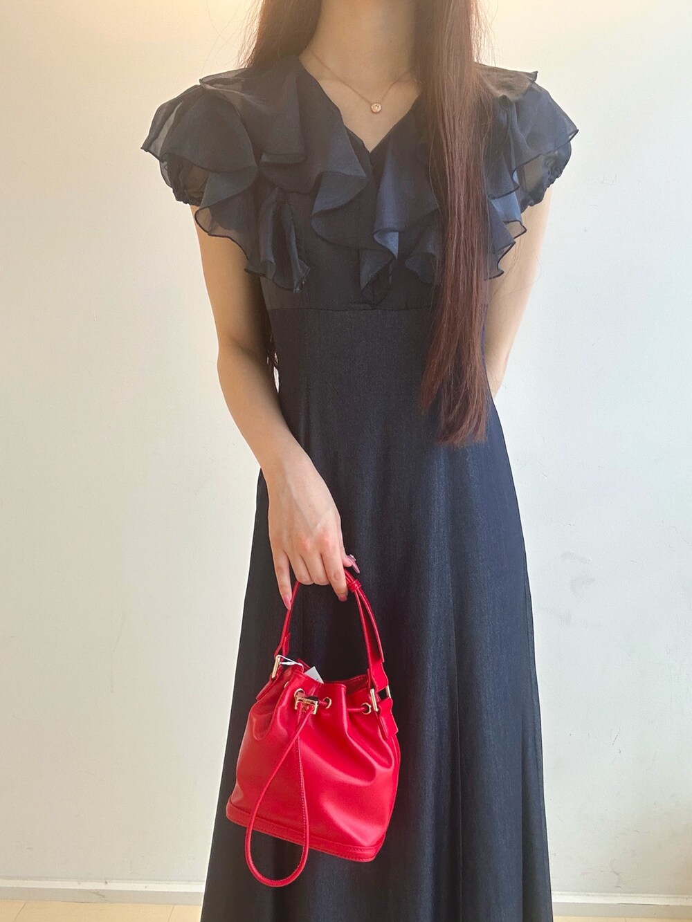 ブルー系のワンピース、レッド系のハンドバッグ、ブルー系のパンプスを着用したレディースの夏コーディネートの6枚目の写真