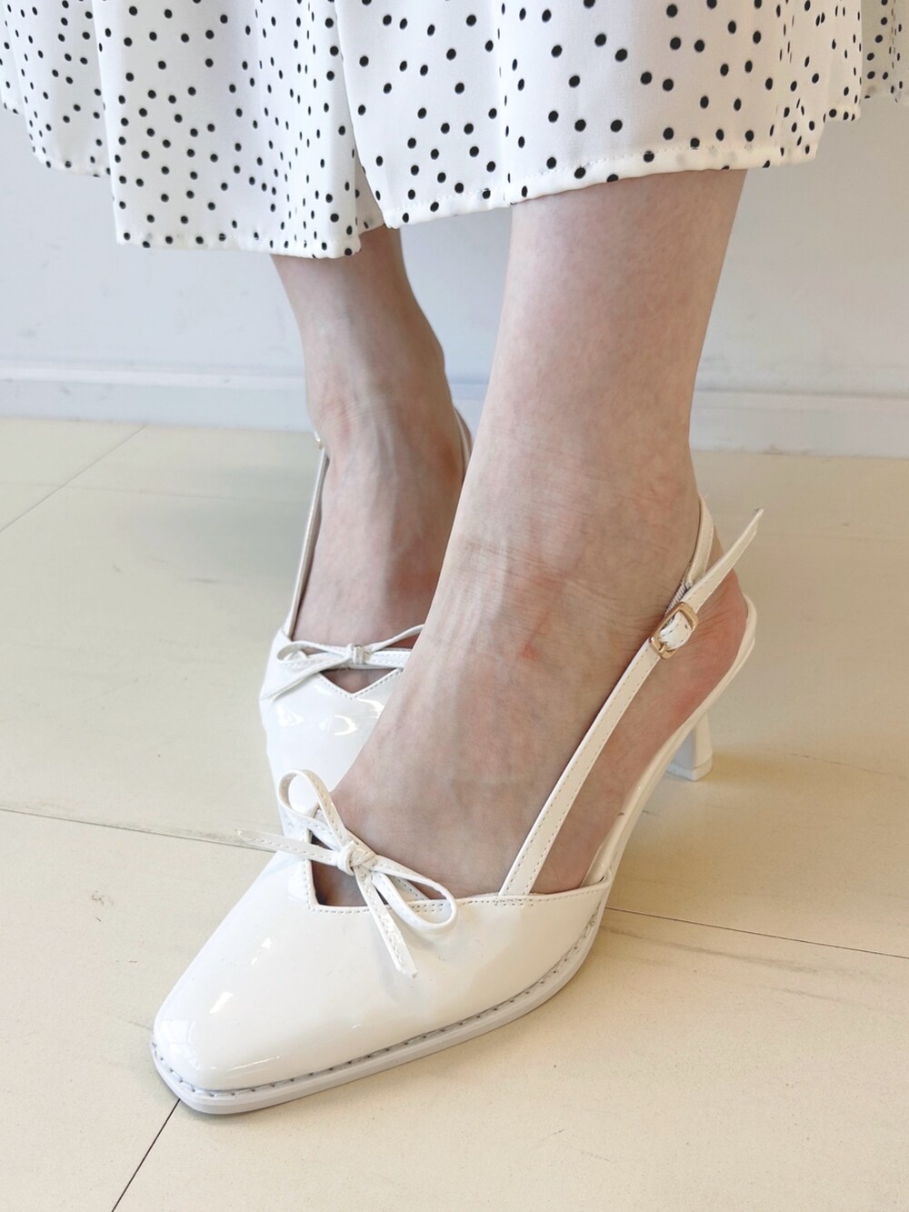 ブラック系のハンドバッグ、ホワイト系のパンプス、ブラウン系のテーラードジャケットを着用したレディースの秋コーディネートの8枚目の写真