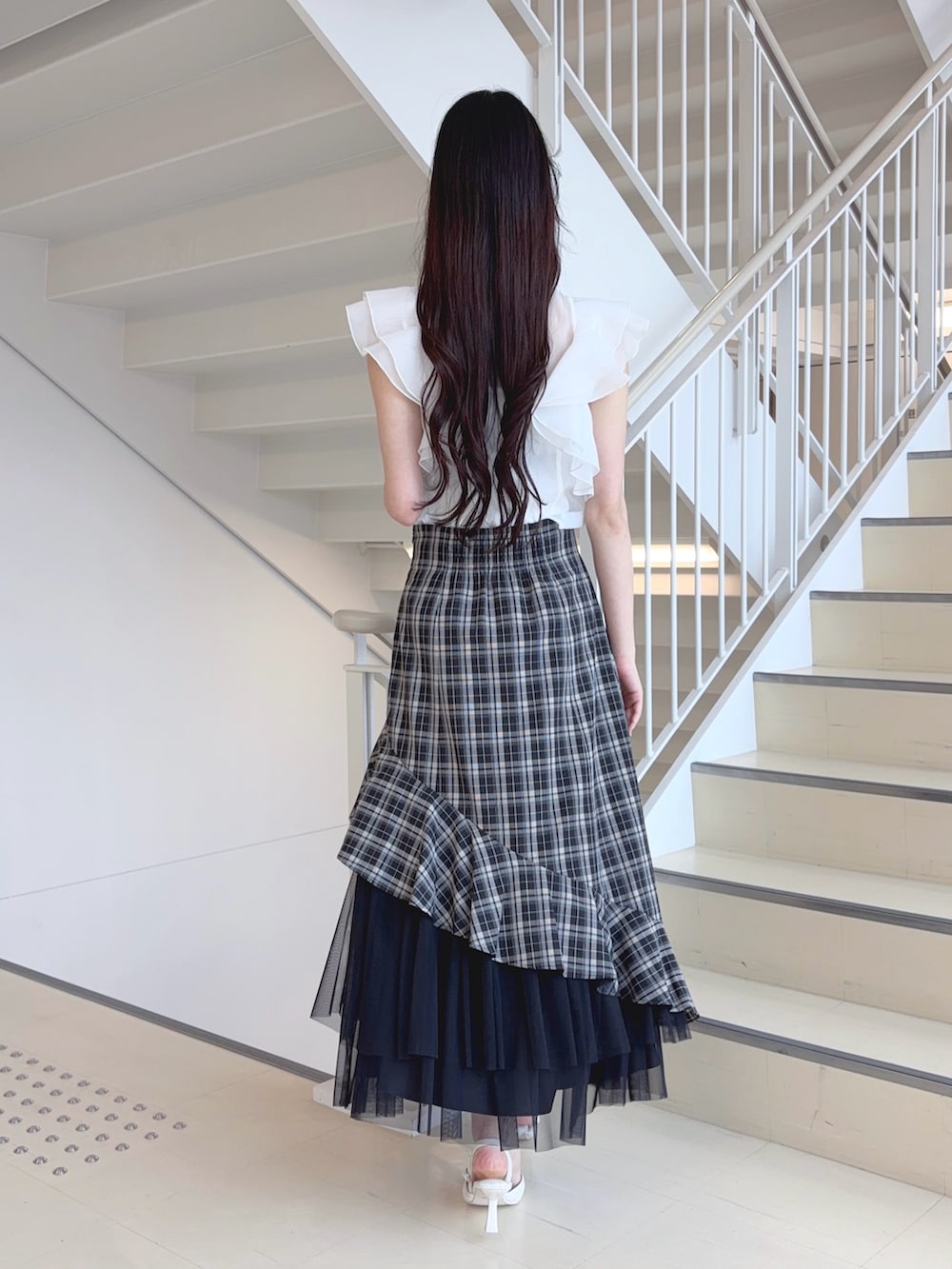 ホワイト系のシャツ/ブラウス、ブラック系のスカート、ホワイト系のパンプスを着用したレディースの夏コーディネートの3枚目の写真