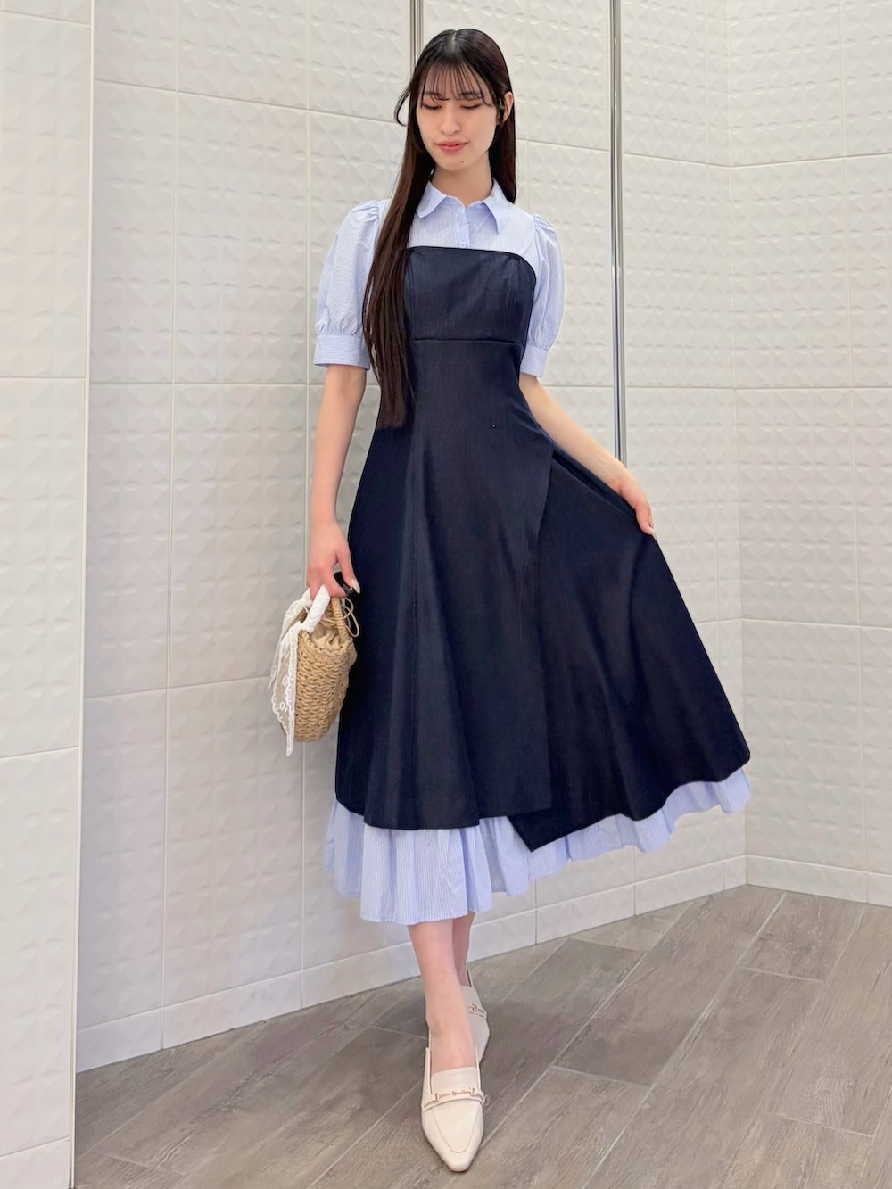 ブルー系のワンピース、ホワイト系のパンプス、ベージュ系のハンドバッグを着用したレディースの春コーディネートの3枚目の写真