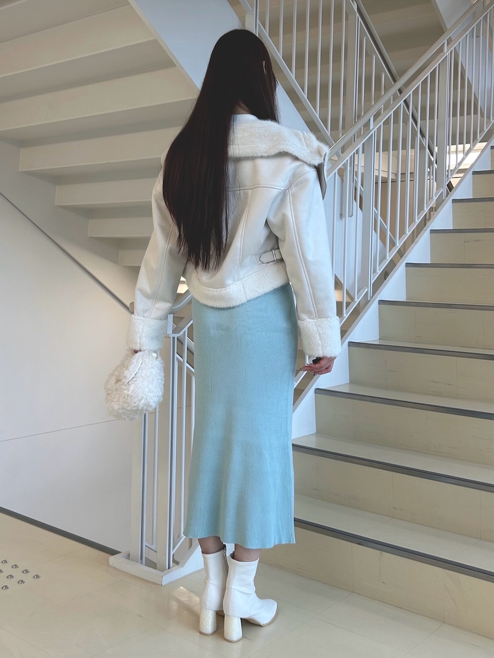 グリーン系のワンピース、ホワイト系のハンドバッグ、ホワイト系のブーツを着用したレディースの秋コーディネートの4枚目の写真