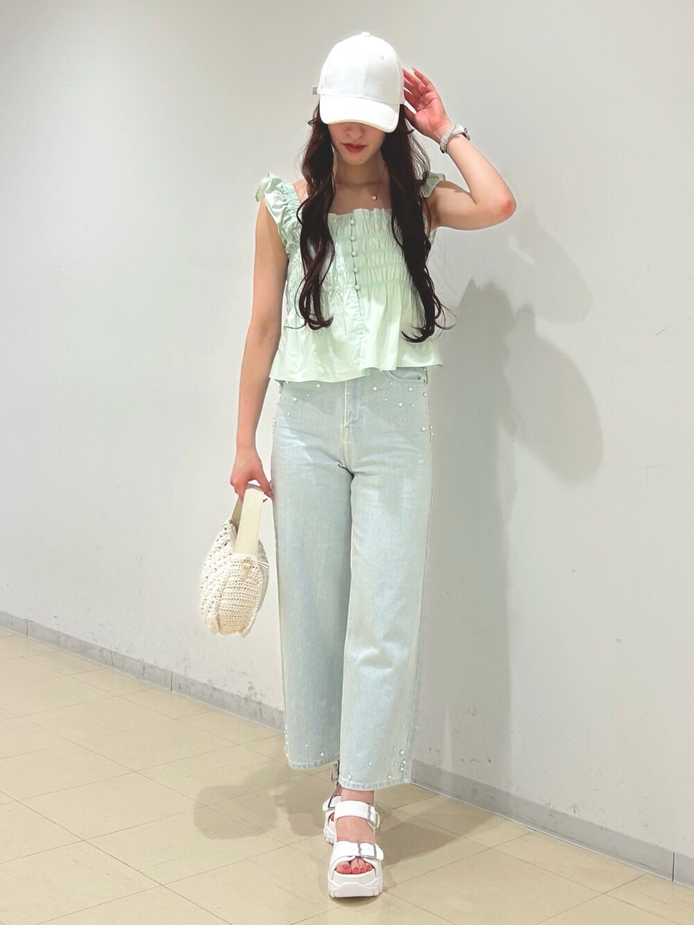 ブルー系のデニムパンツ、グリーン系のシャツ/ブラウス、ホワイト系のショルダーバッグを着用したレディースの春コーディネートの3枚目の写真