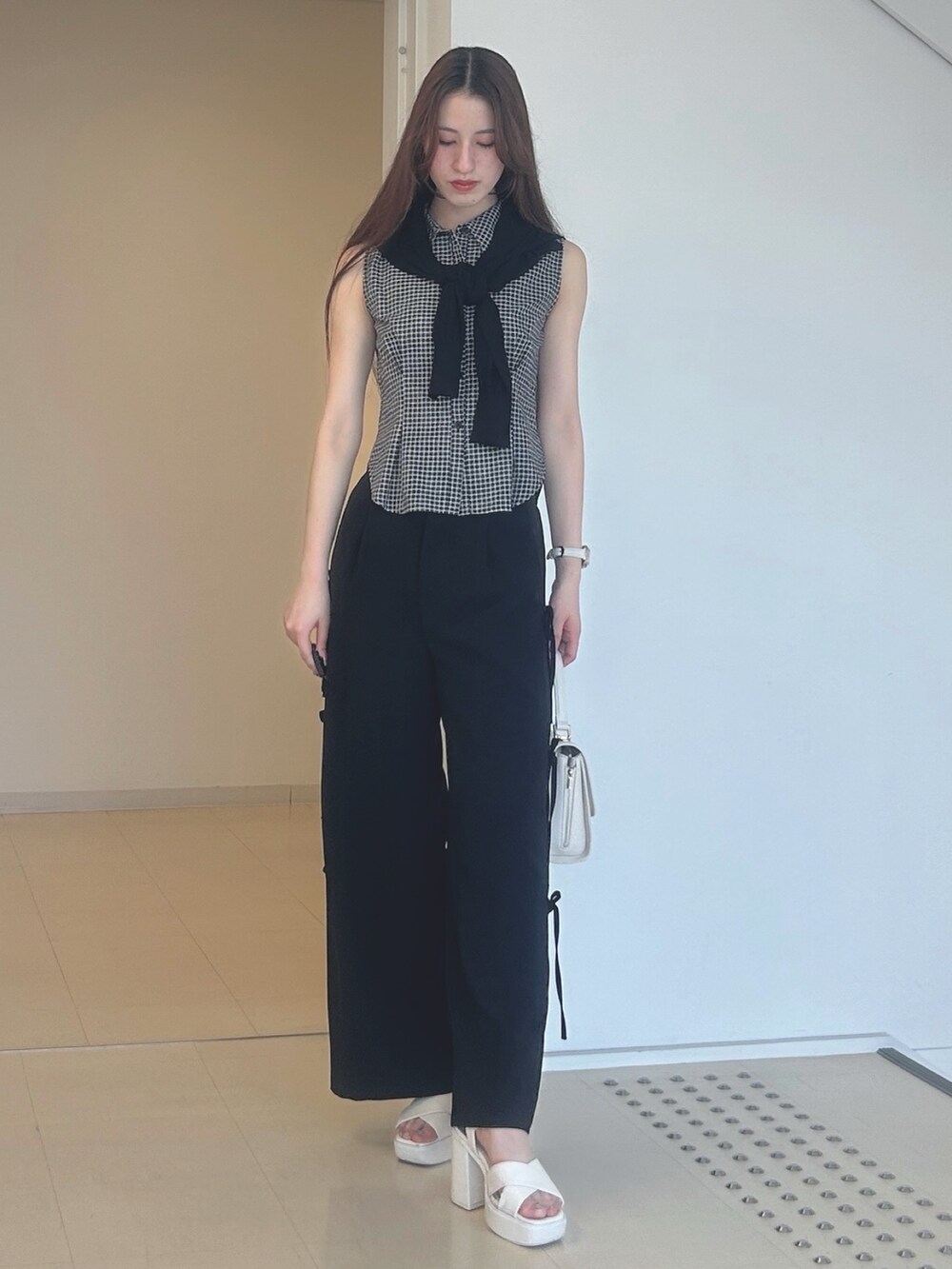 ブラック系のその他パンツ、ホワイト系のサンダル、ホワイト系のハンドバッグを着用したレディースの夏コーディネートの3枚目の写真
