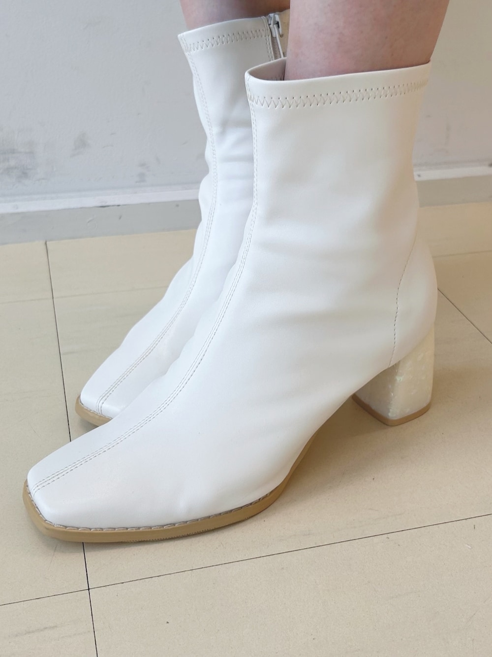 グリーン系のワンピース、ホワイト系のハンドバッグ、ホワイト系のブーツを着用したレディースの秋コーディネートの7枚目の写真